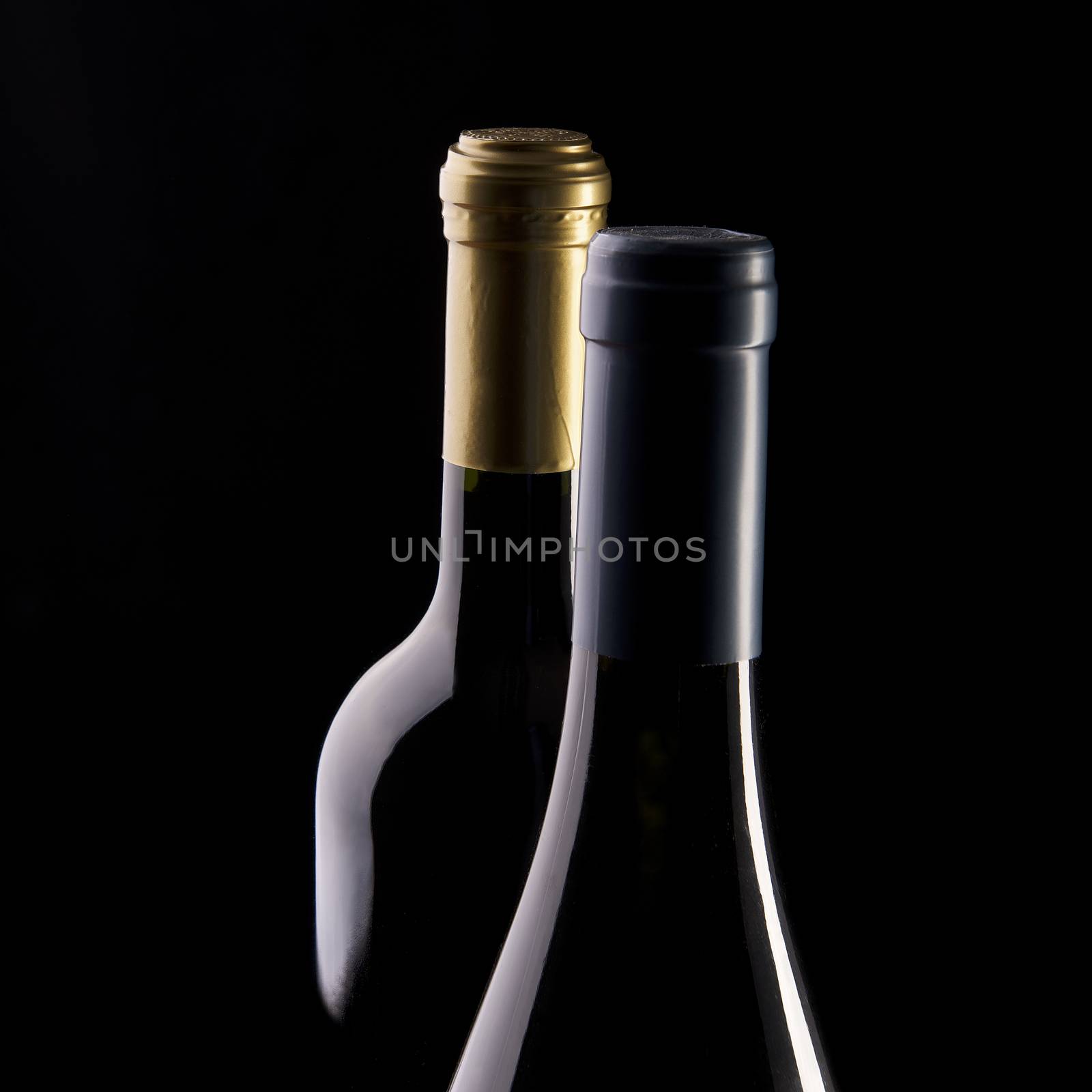 two bottles of wine with a black background