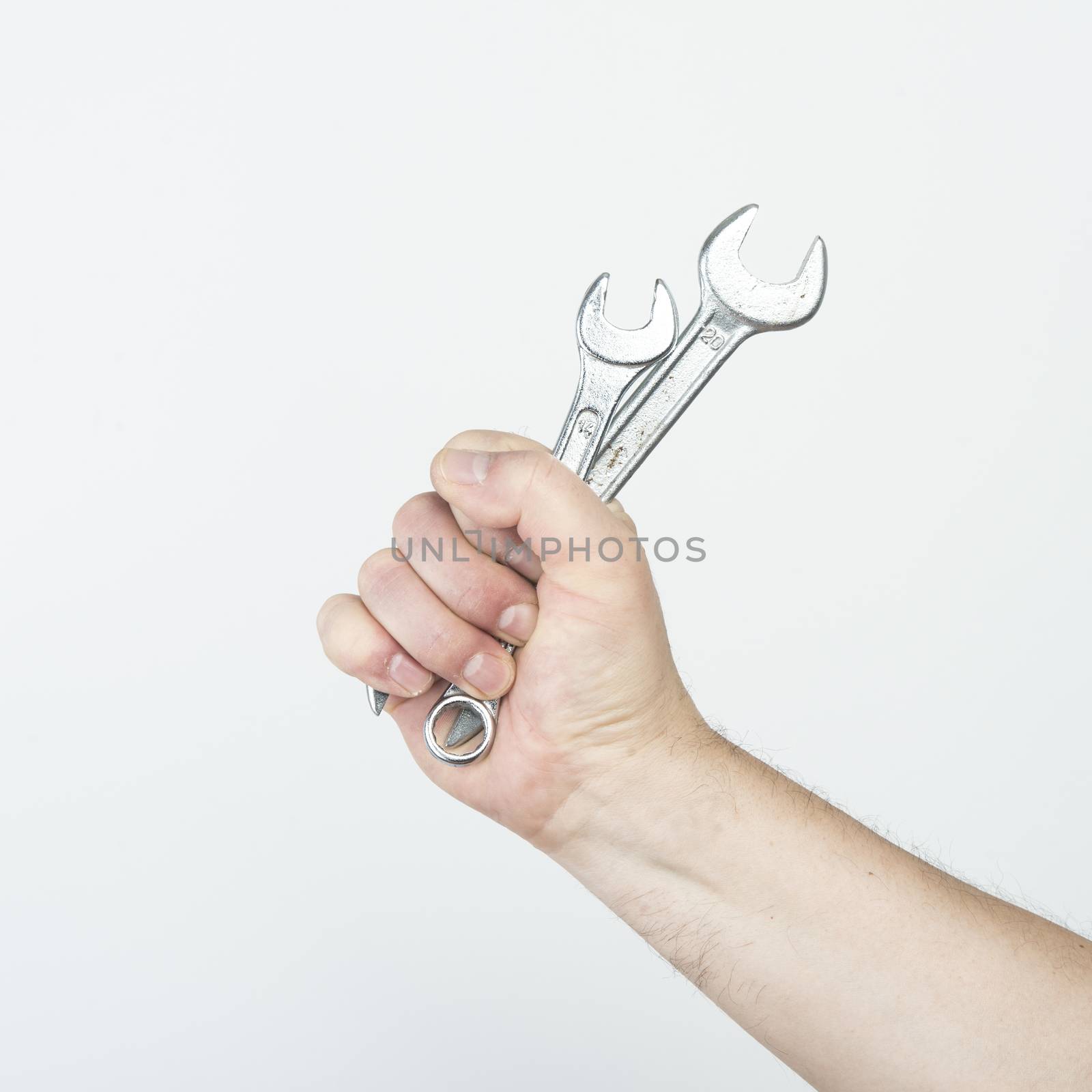 two wrenches in his hand