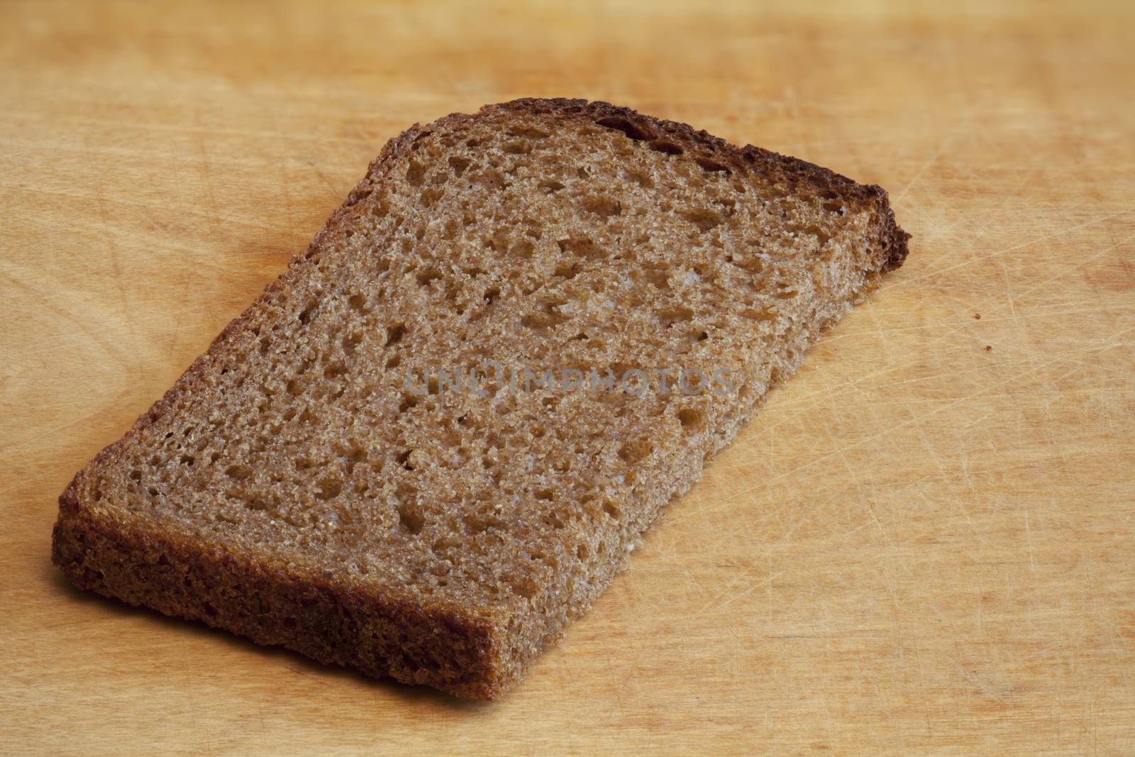 piece of rye bread on a cutting board by mrivserg
