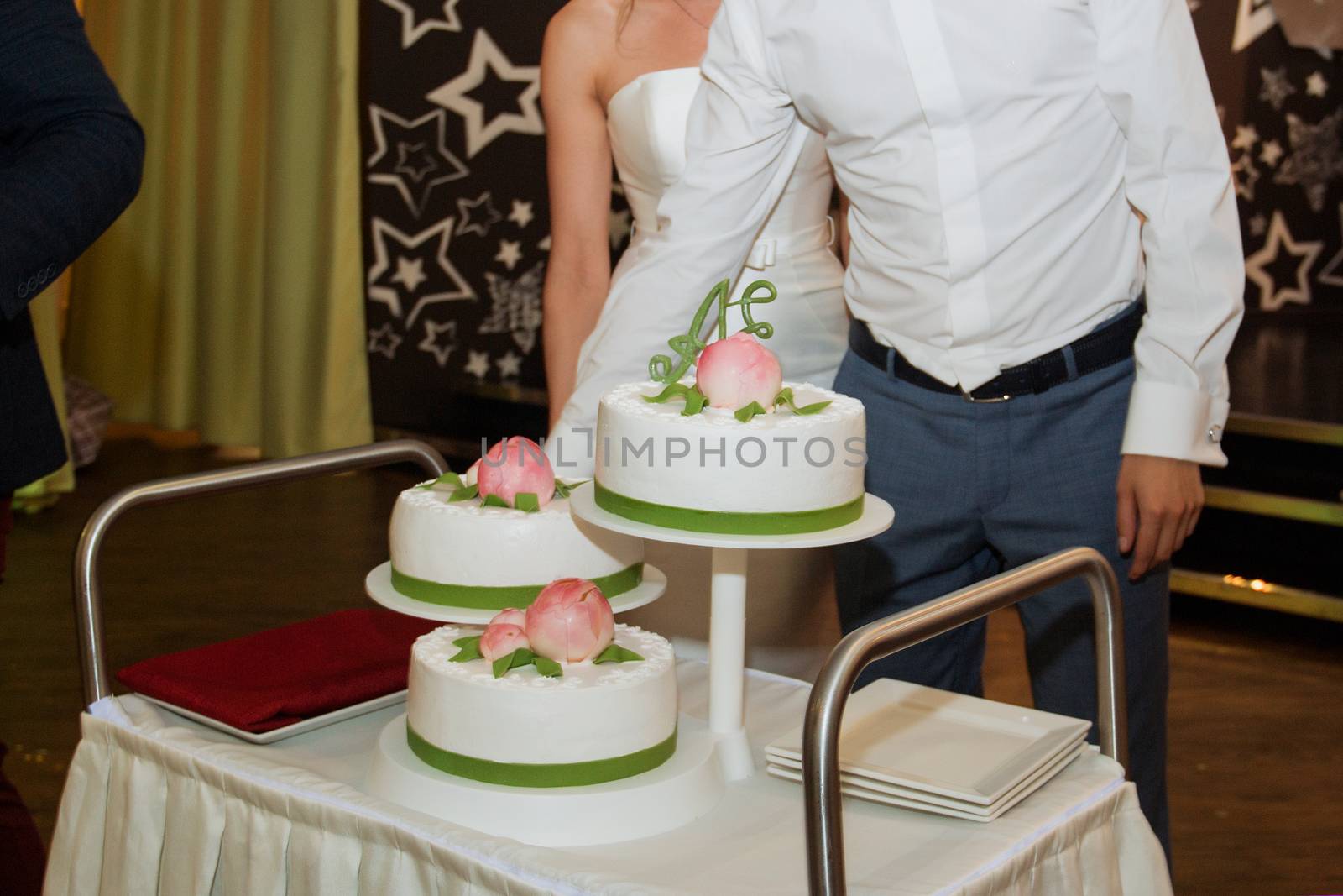 elegant pretty young bride and groom cut the wedding cake by 3KStudio