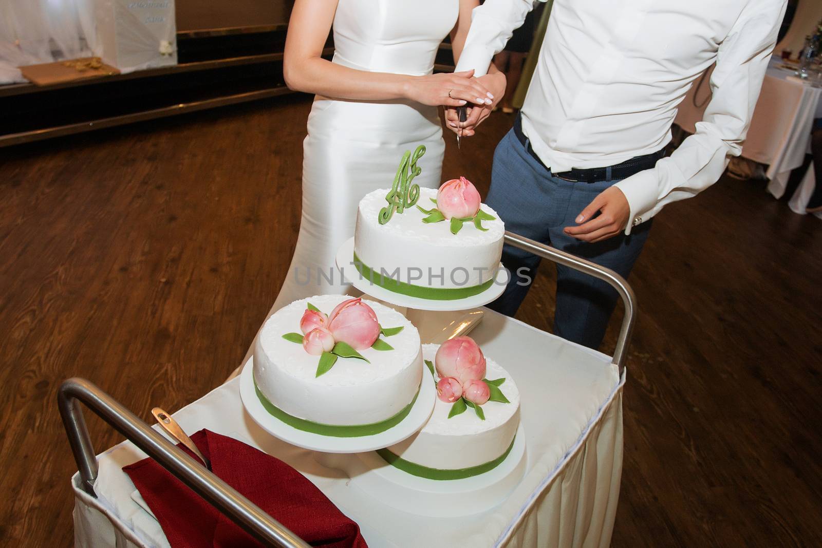 elegant pretty young bride and groom cut the wedding cake by 3KStudio