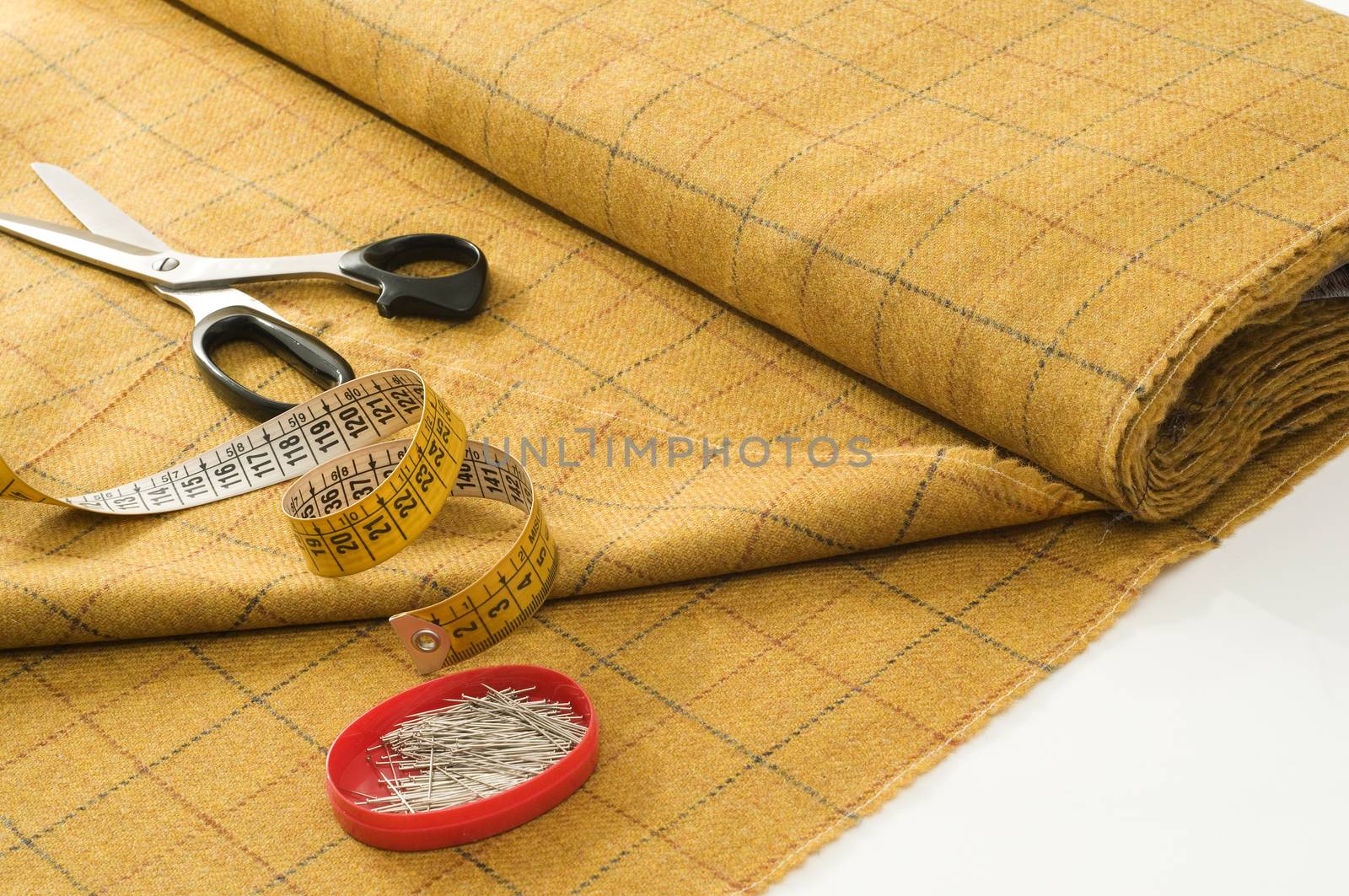 piece of fabric with scissors, pins and tape measure