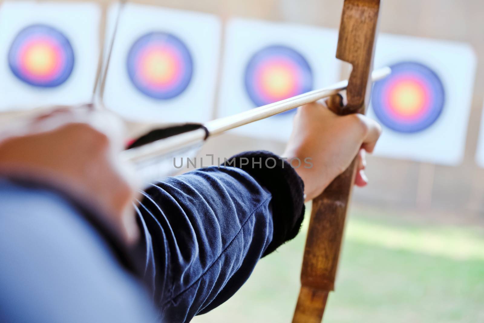 Archer holds his bow aiming at a target
