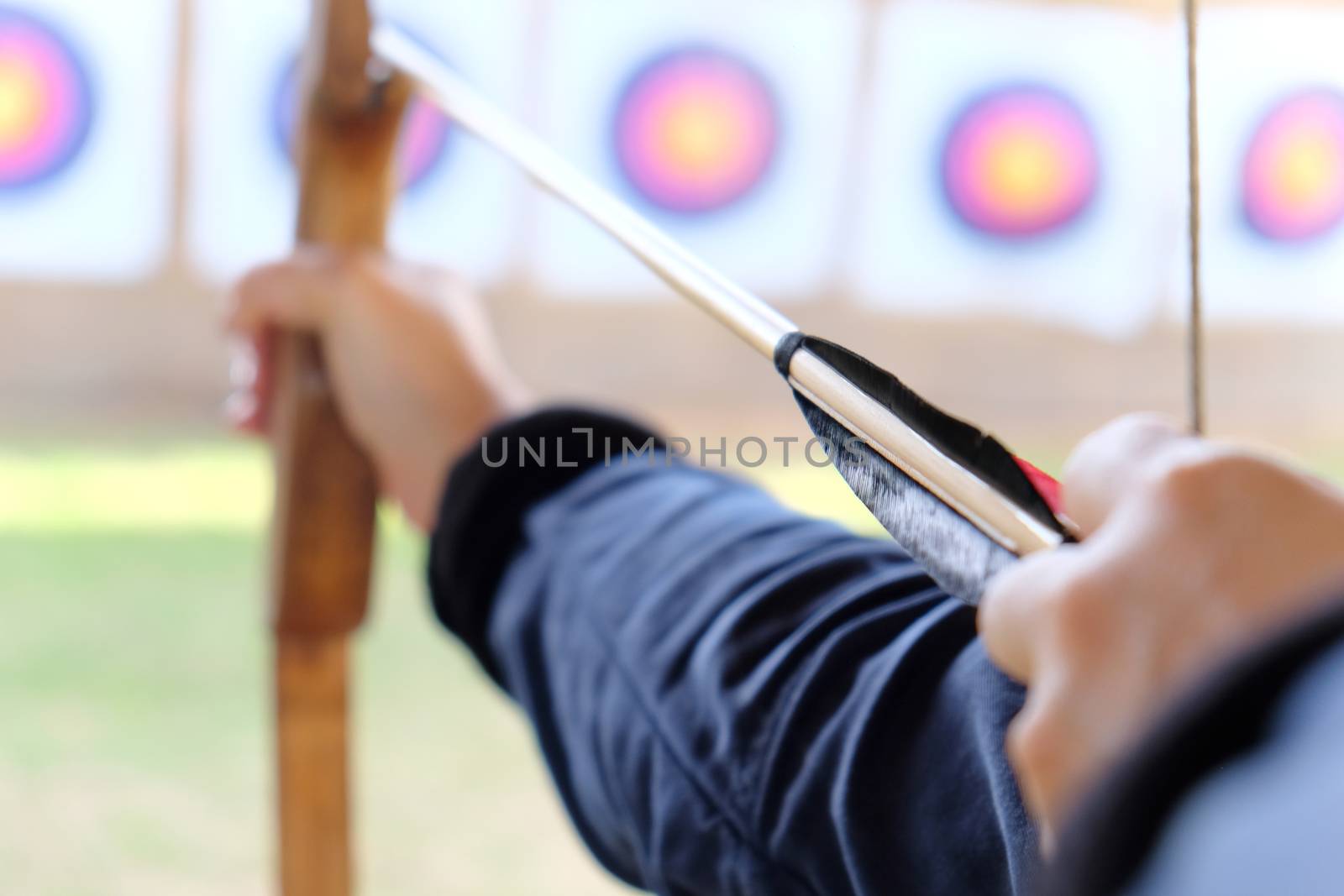 Archer holds his bow aiming at a target