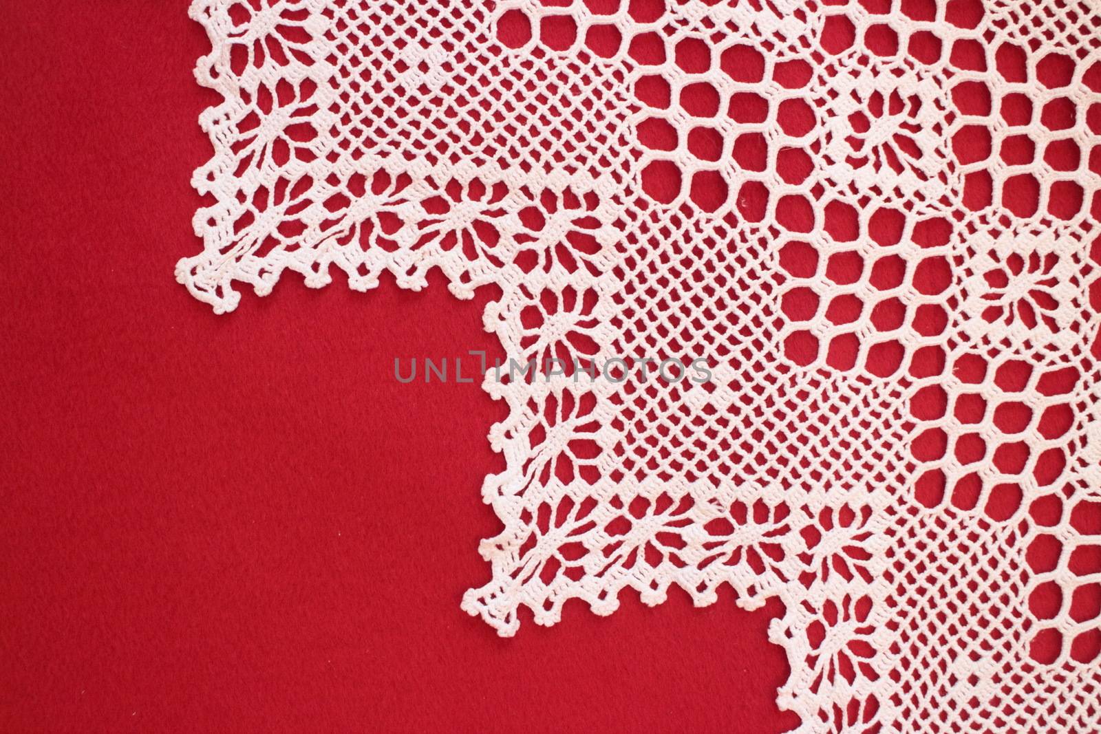 handmade lace on red background with copy space. conceptual image wedding or holiday 