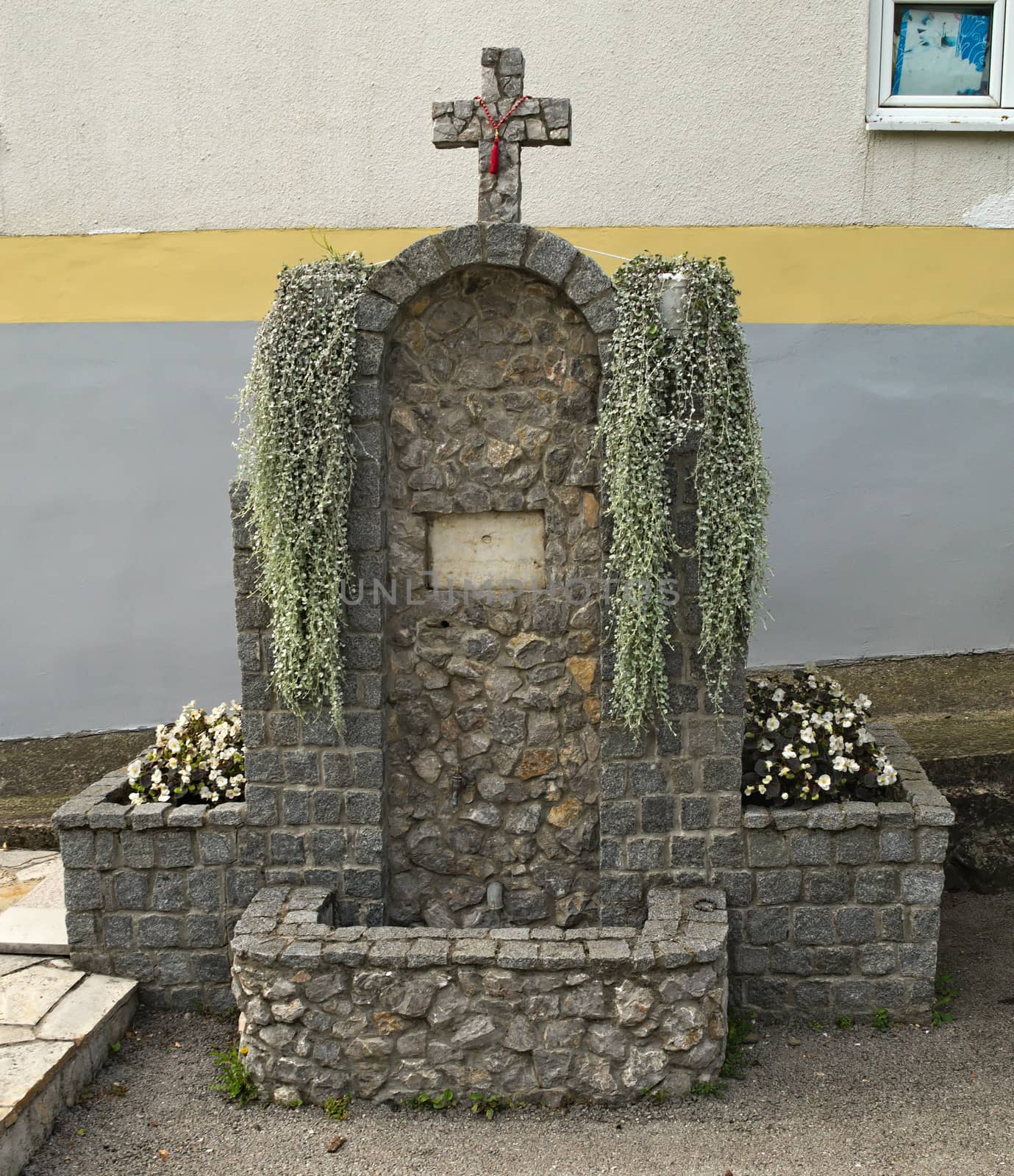 Small fountain and religious mosaic in monastery yard, Serbia