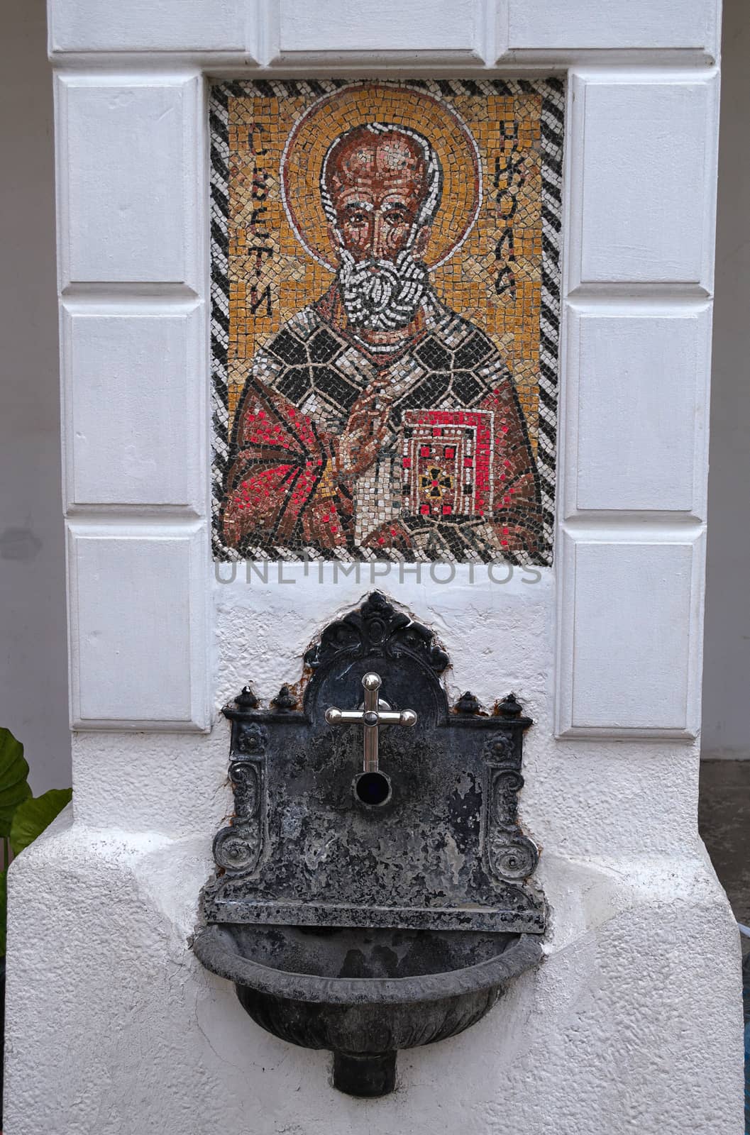 Small fountain and religious mosaic in monastery yard, Serbia