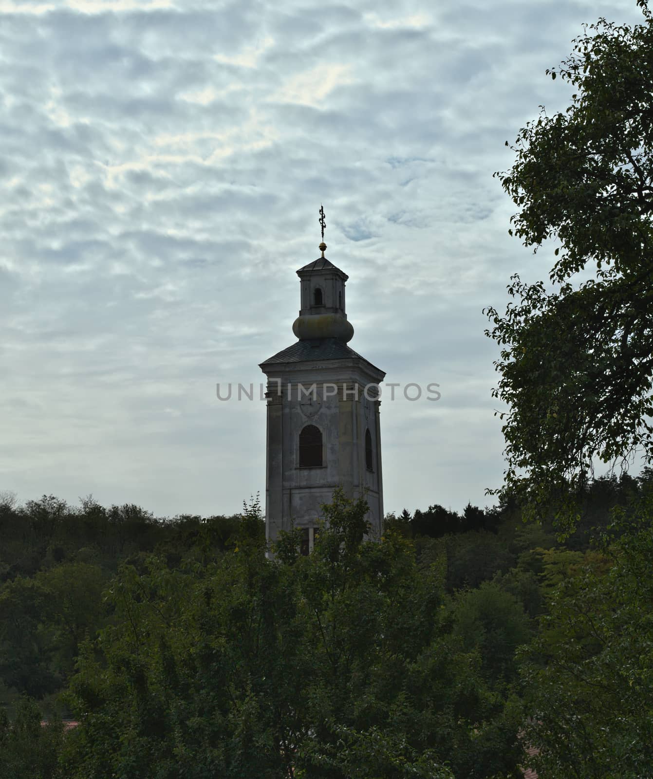 Tower of monastery church, forest and sky around