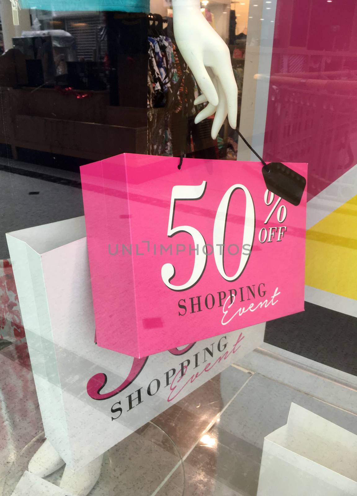 Boutique mannequin holding a shopping bag with /sale sign avertisement