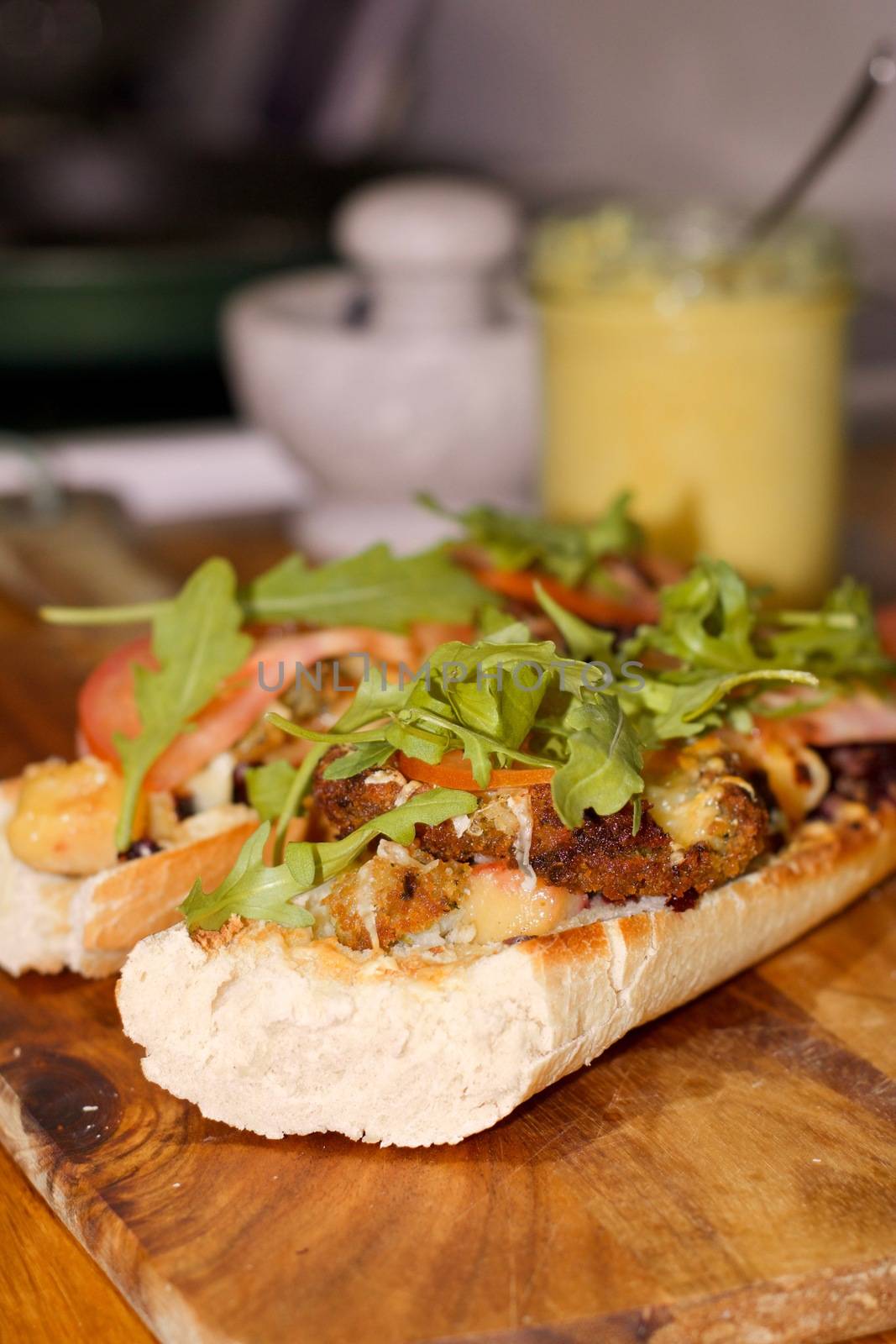 Delicious sandwich on the wooden board in the kitchen.