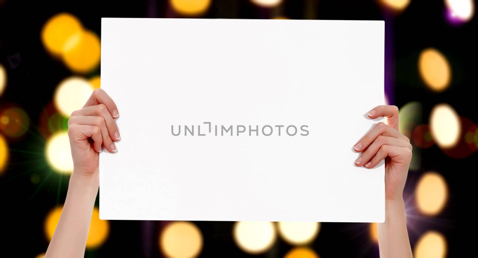 Female hands holding a blank placard with abstract lights bokeh background