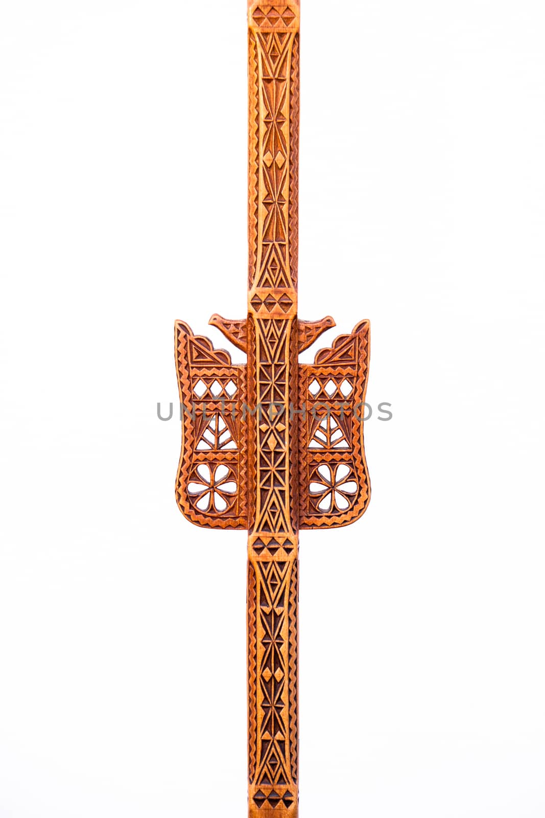 A hand-made work of art of an folk artisan carved decoration in a single piece of wood with geometric shapes and symbols for bird, flower, snake and pine-tree