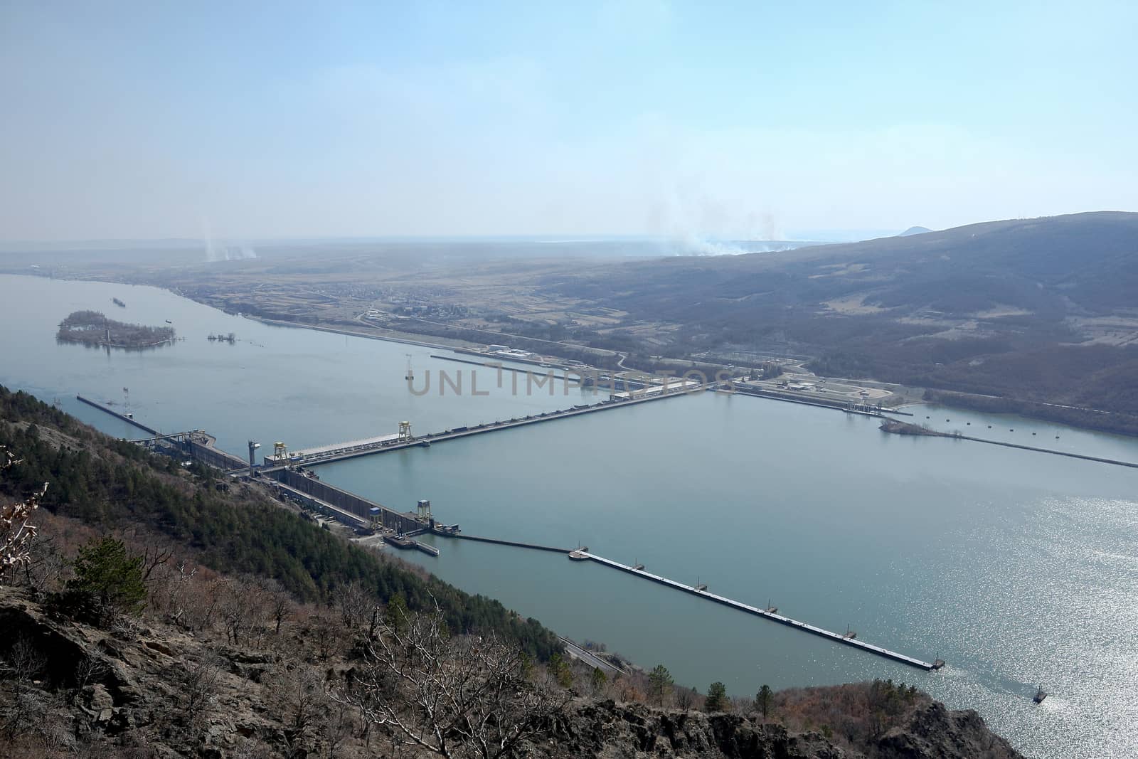 A very big hydroelectric power plant situated on a big river with bridge and sluice gates