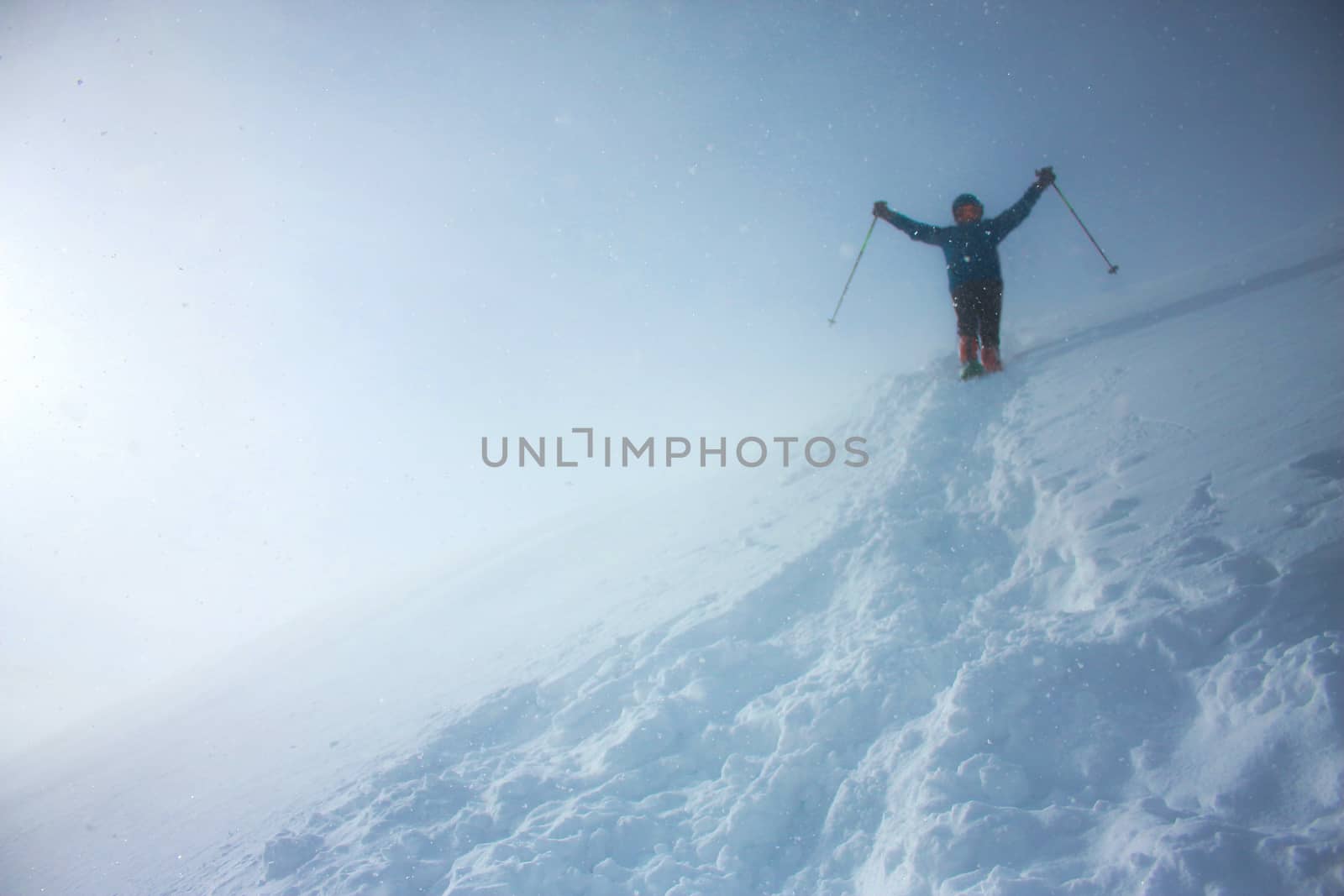 A mountaineer descending the slope with a salute raising both hands