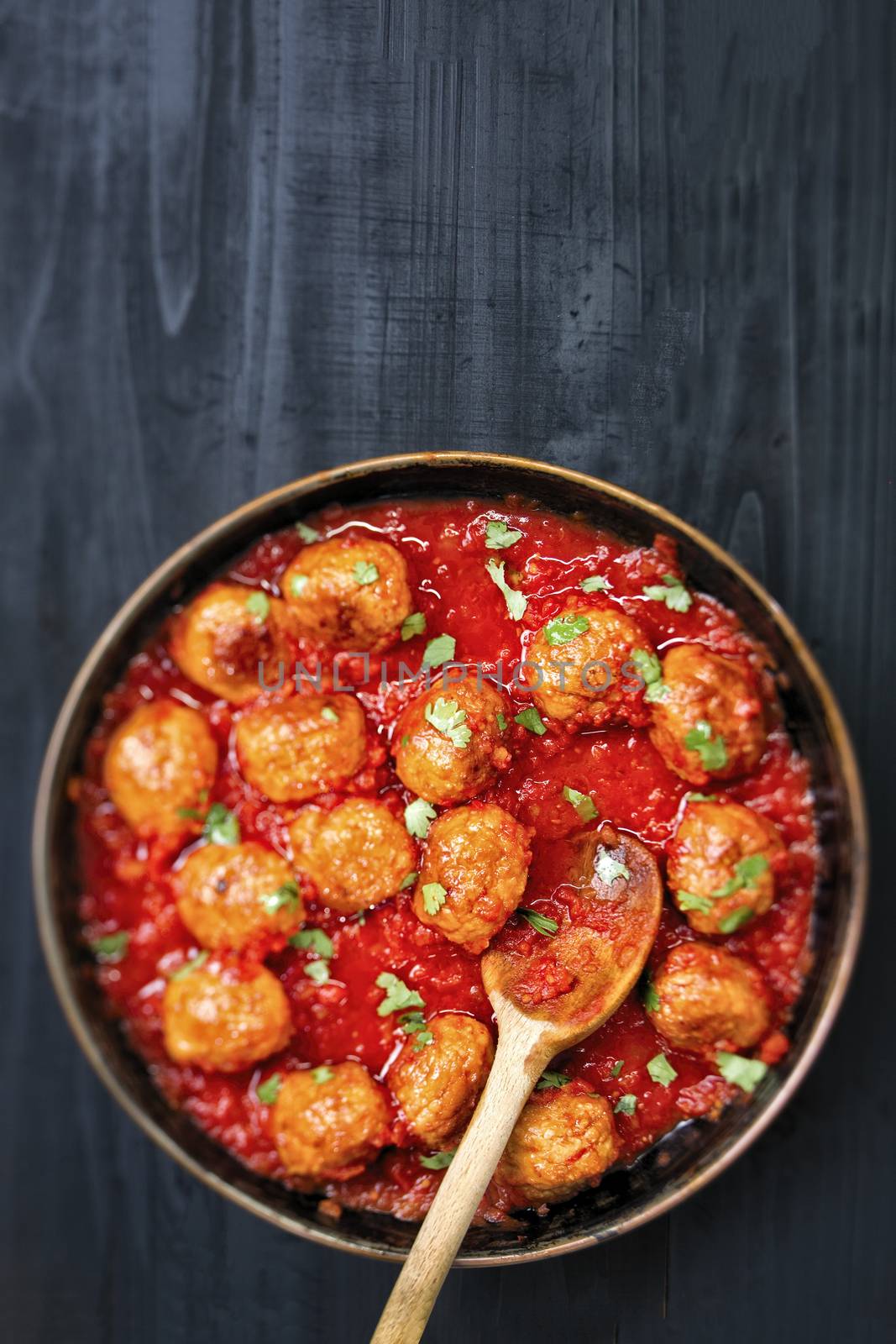 close up of rustic italian meatball in tomato sauce