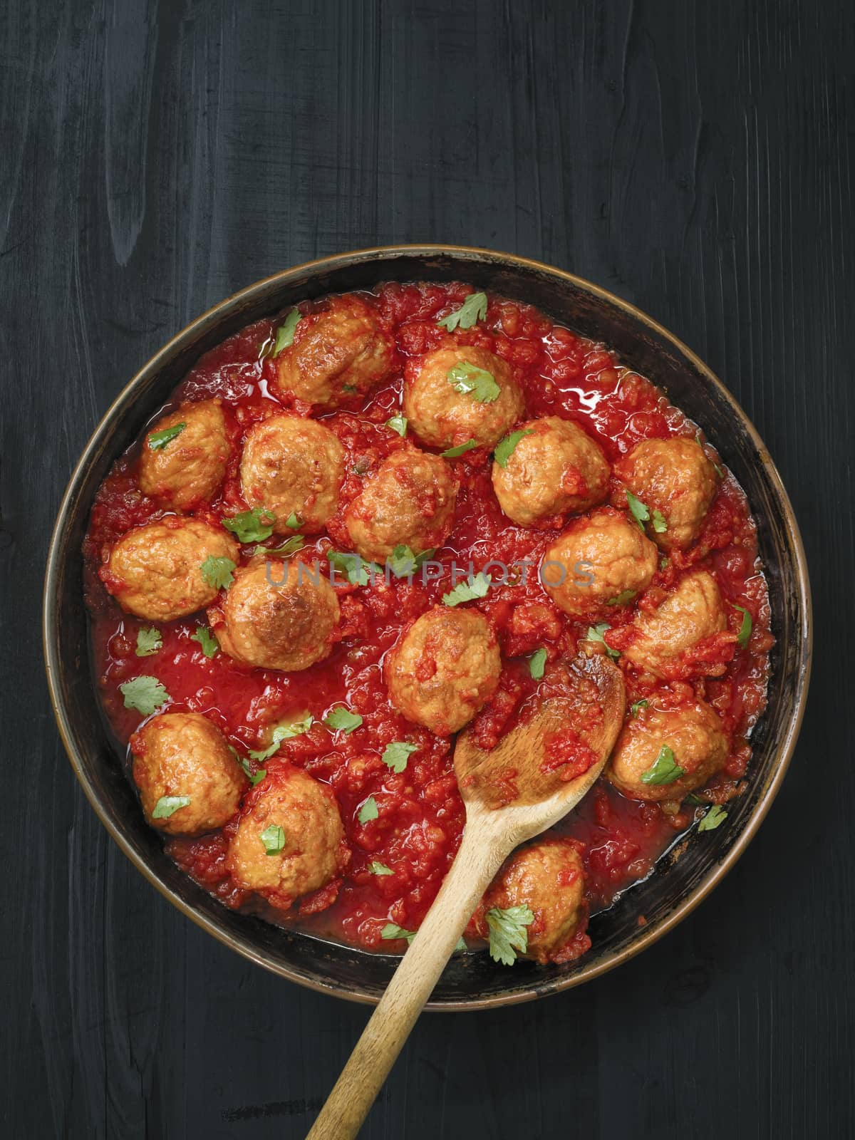 close up of rustic italian meatball in tomato sauce