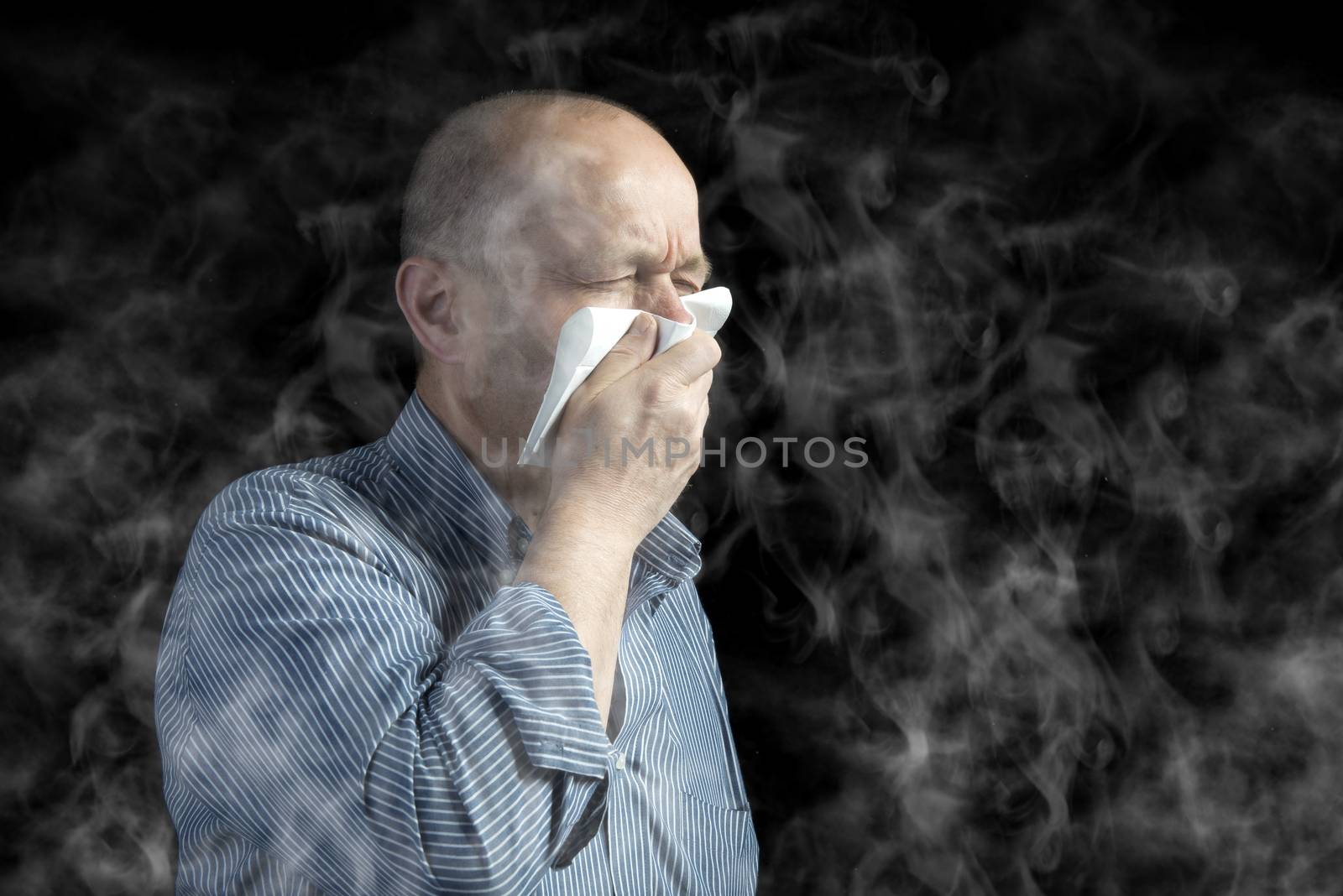 a man covers his mouth to protect himself from the smoke in the environment