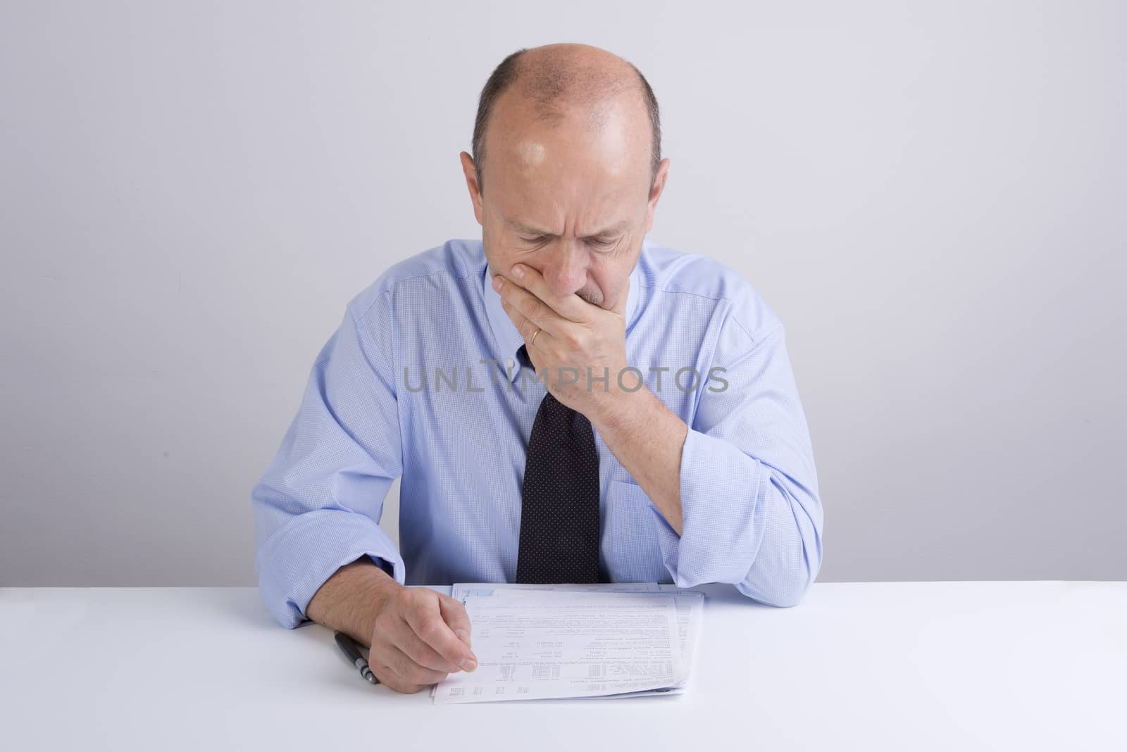 a worried man reading a document