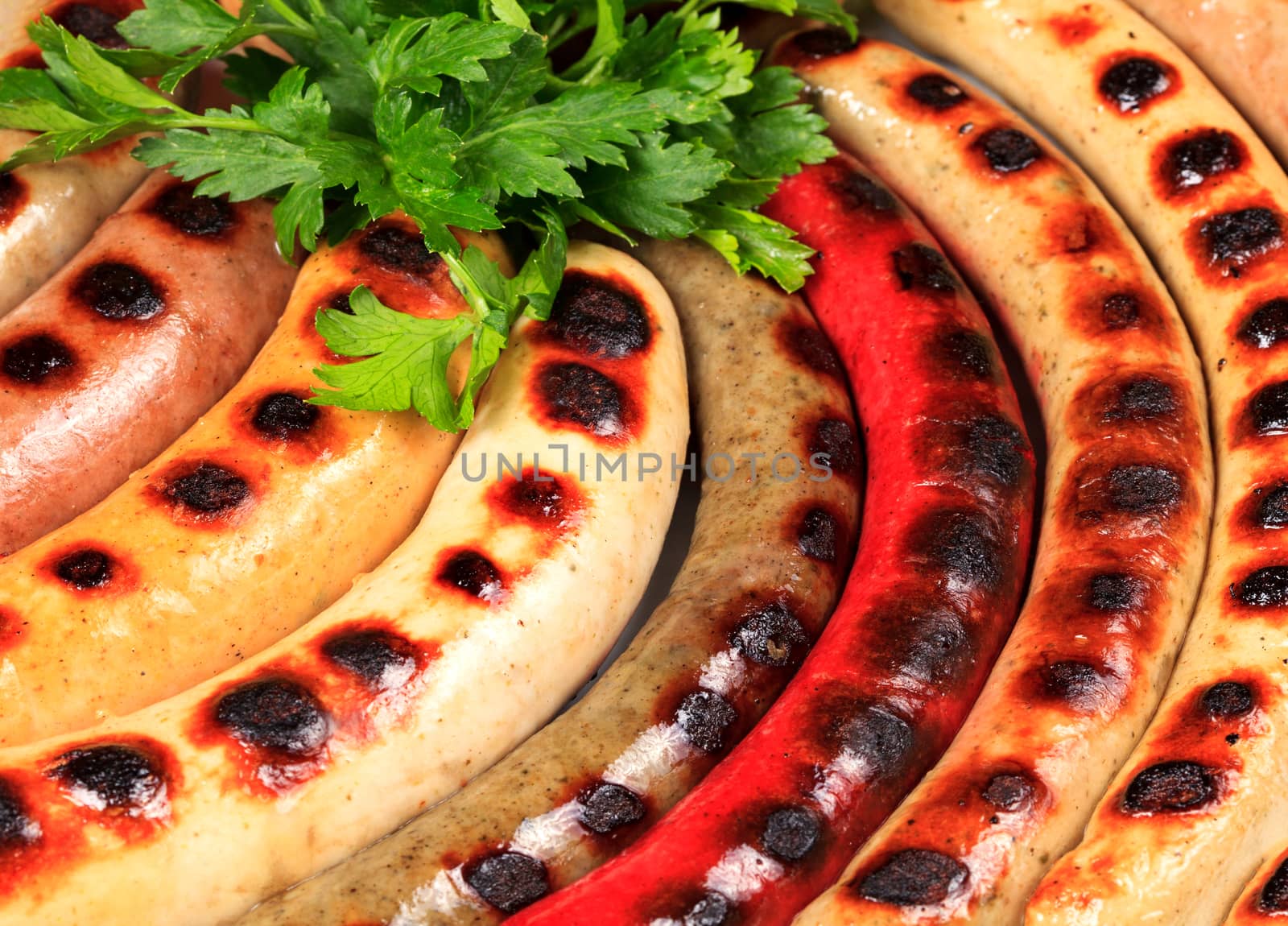 Closeup shot of sausages with green herbs on a plate by Nobilior