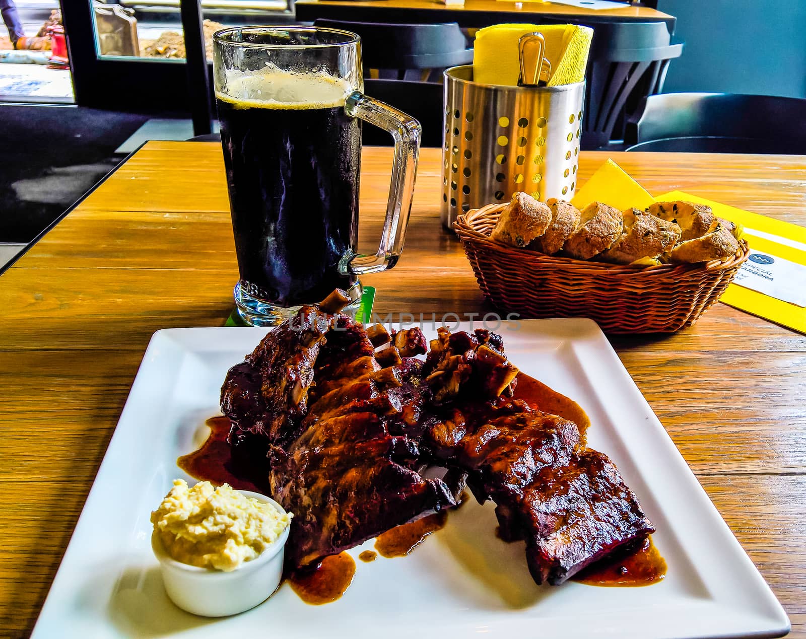 Mug of beer and plate of grilled pork ribs in Prague, Czech Repu by homocosmicos