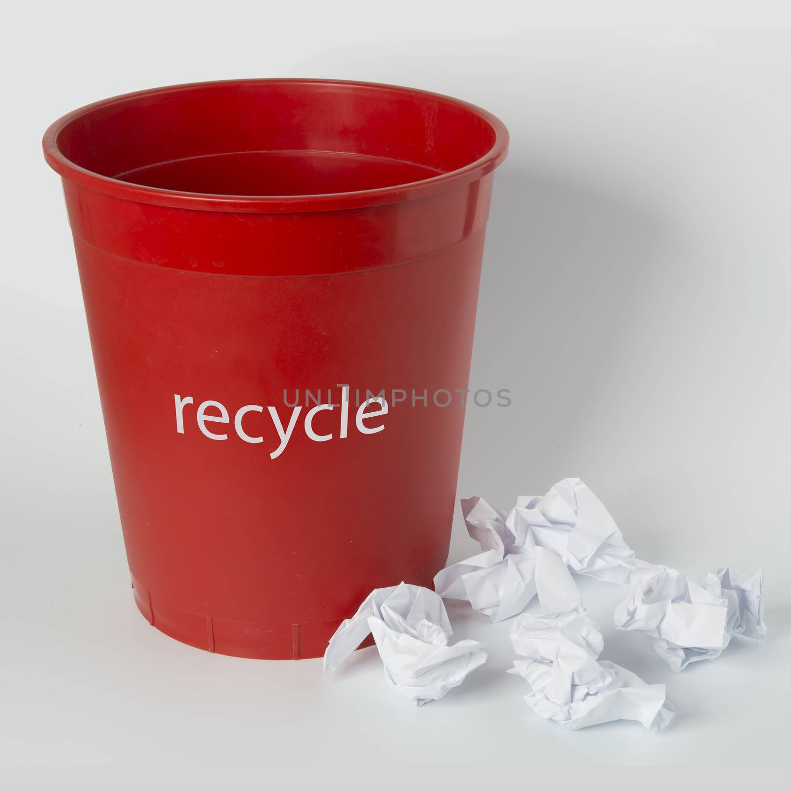 a red wastebasket for collecting waste paper