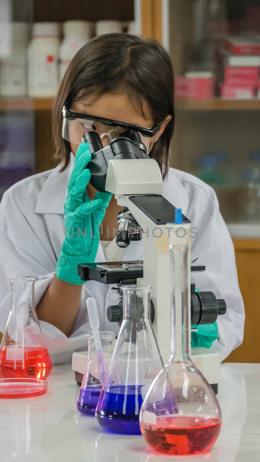 girl looking with microscope  by rakratchada