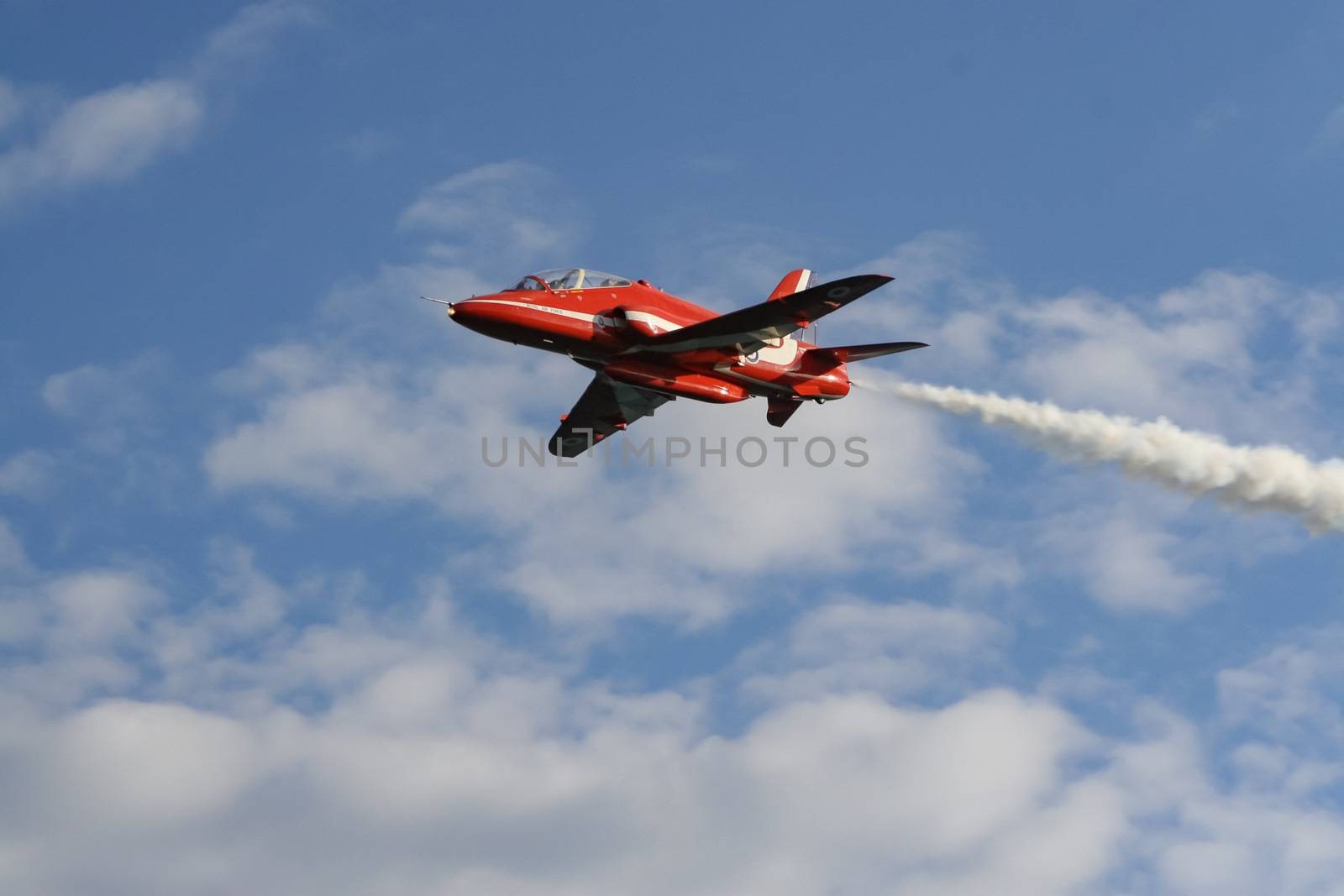 A royal air force red arrow air display flying overhead in england.