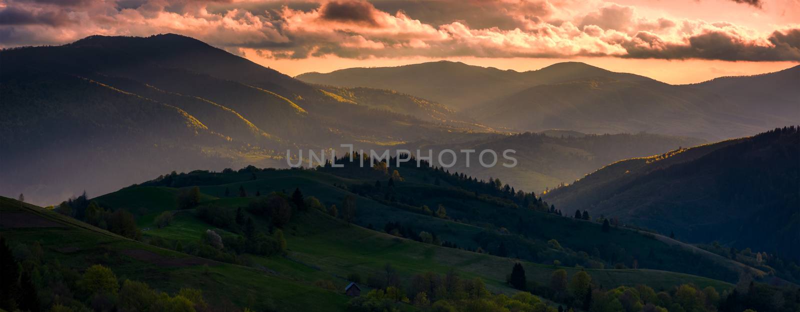 red sunset in mountainous countryside. gorgeous panorama of Carpathian mountains with cloudy sky in springtime
