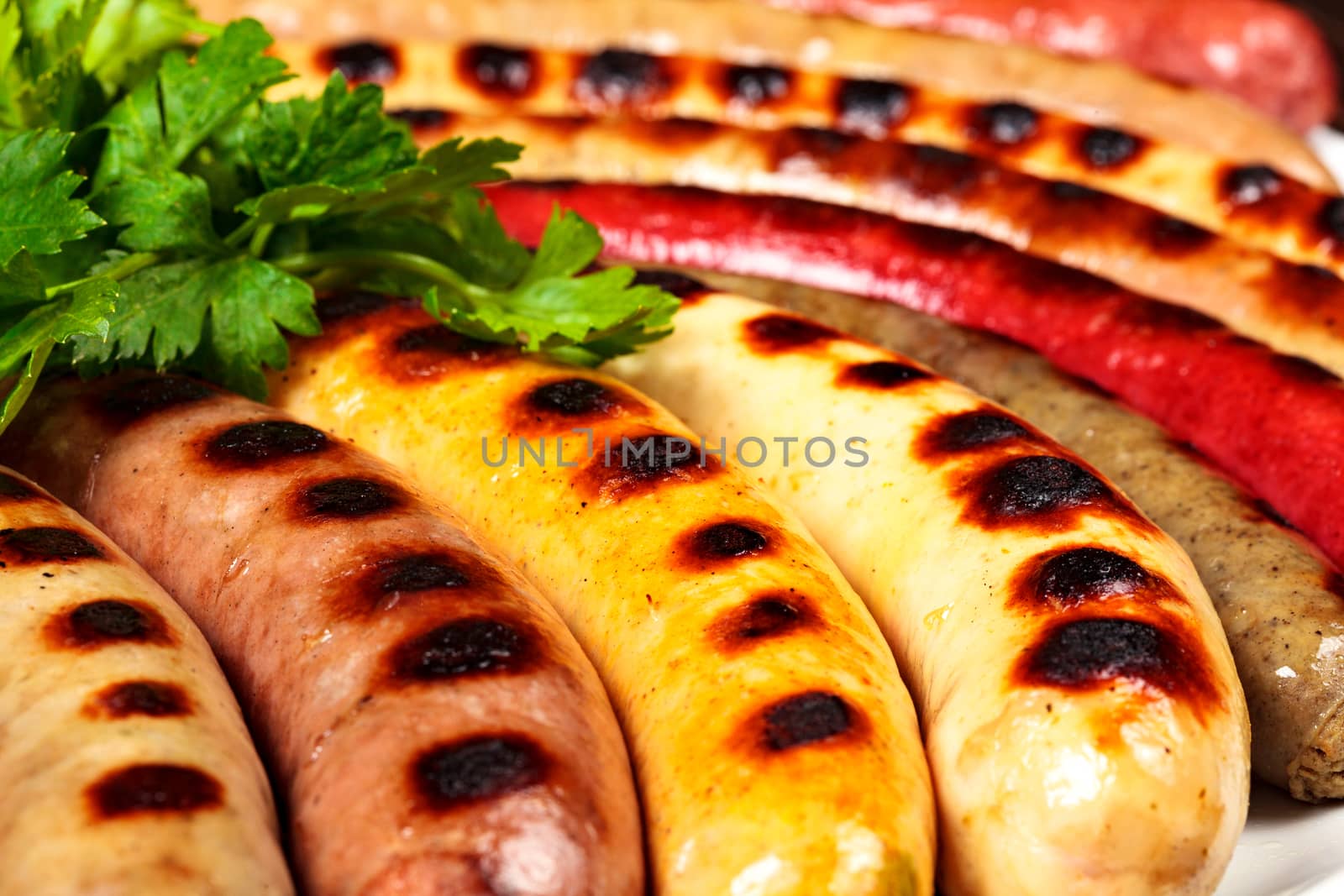 Closeup shot of sausages with green herbs on a plate by Nobilior