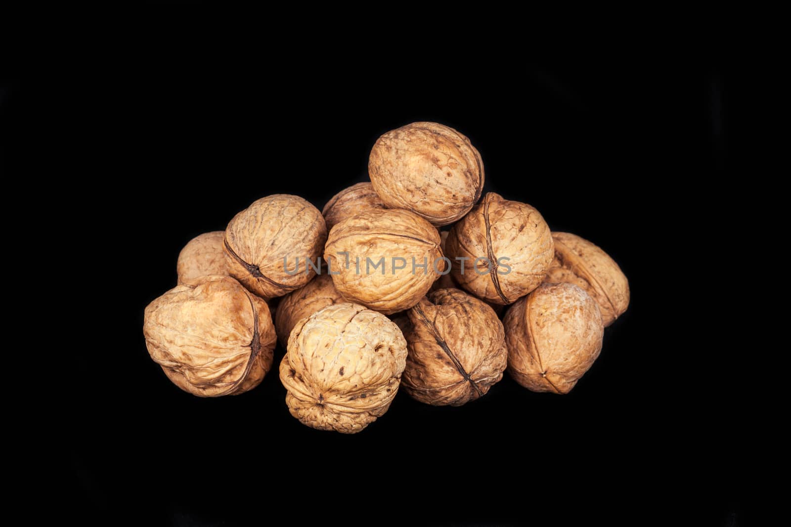 A pile of walnuts on black background by shoricelu