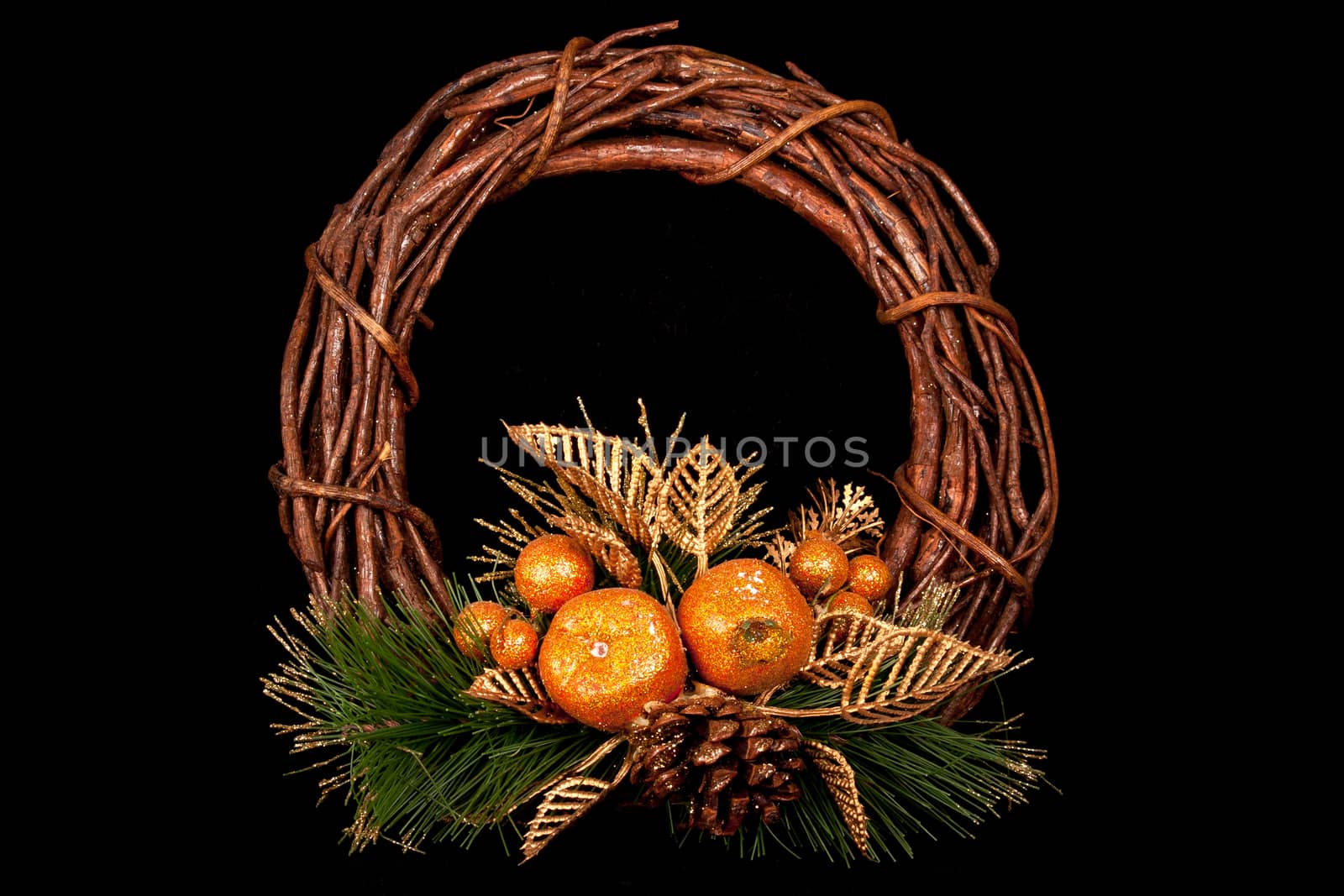 Round shaped wood wicker with a base from natural pine leafs and some shining fruits gilded in golden polish
