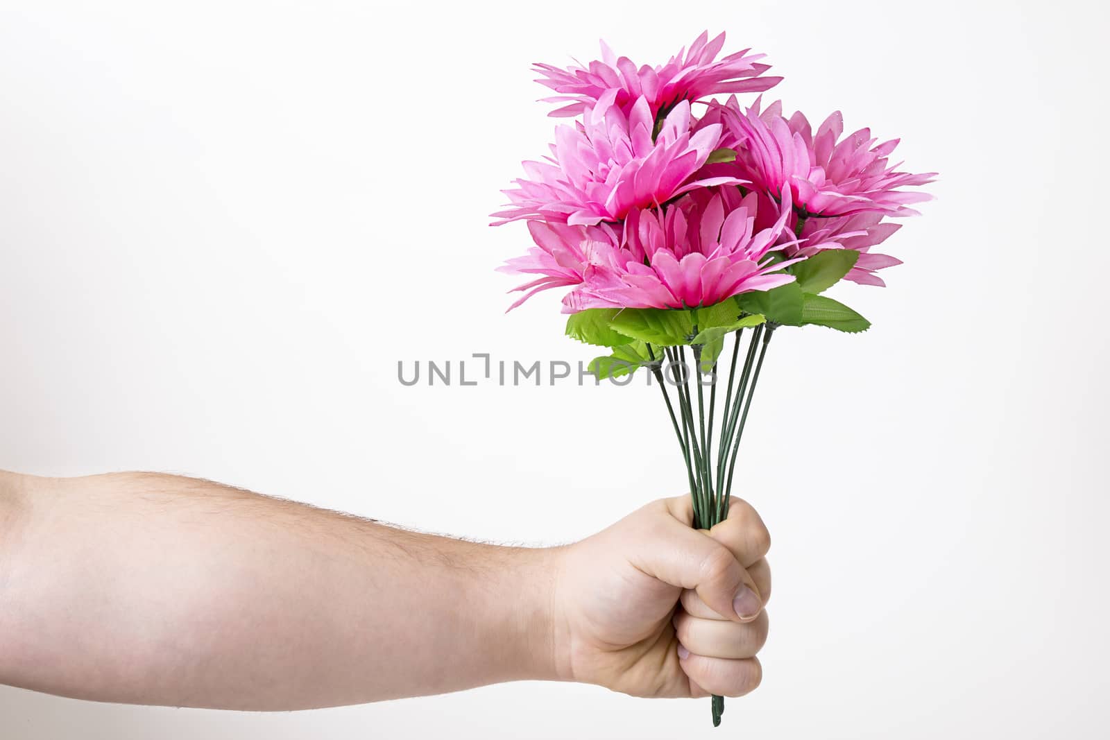 man arms holding a bouquet of pink fake flower