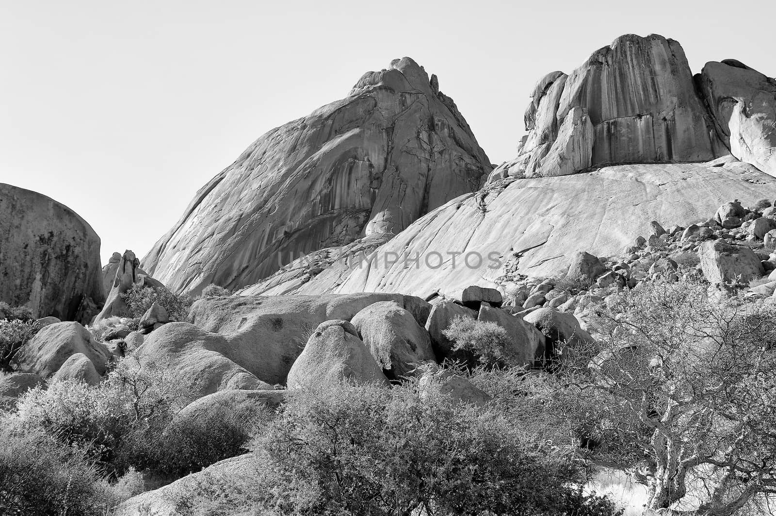 Spitzkoppe with sandstone boulders in the foreground, Namibia. Monochrome
