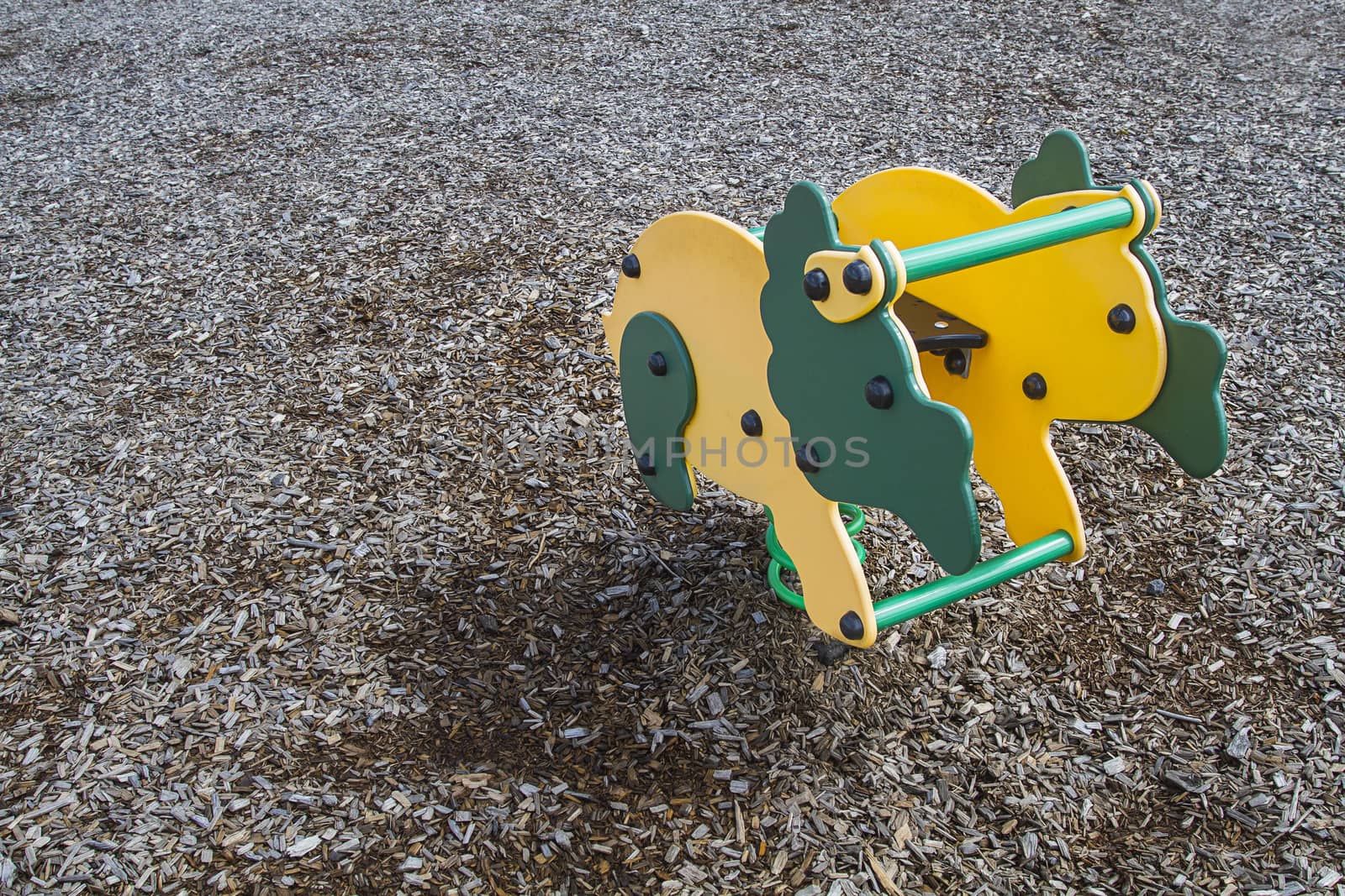 Park game in the shape of a Triceratop on wood chip ground