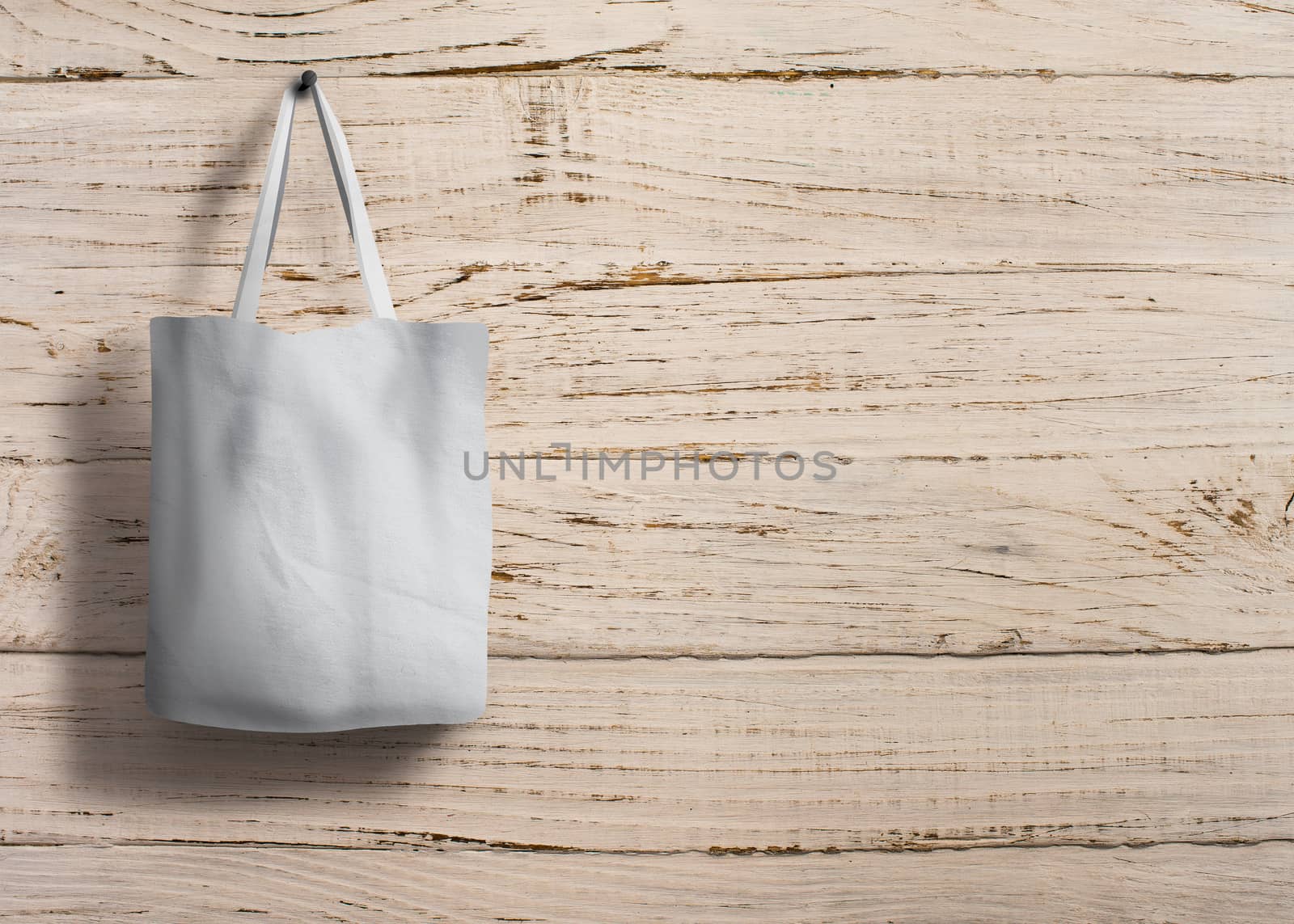 shopping bag of cotton weighs on the screw on wooden background