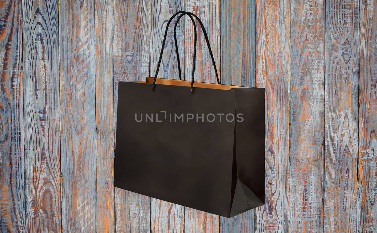 paper bag for shopping on a wooden background by boys1983@mail.ru