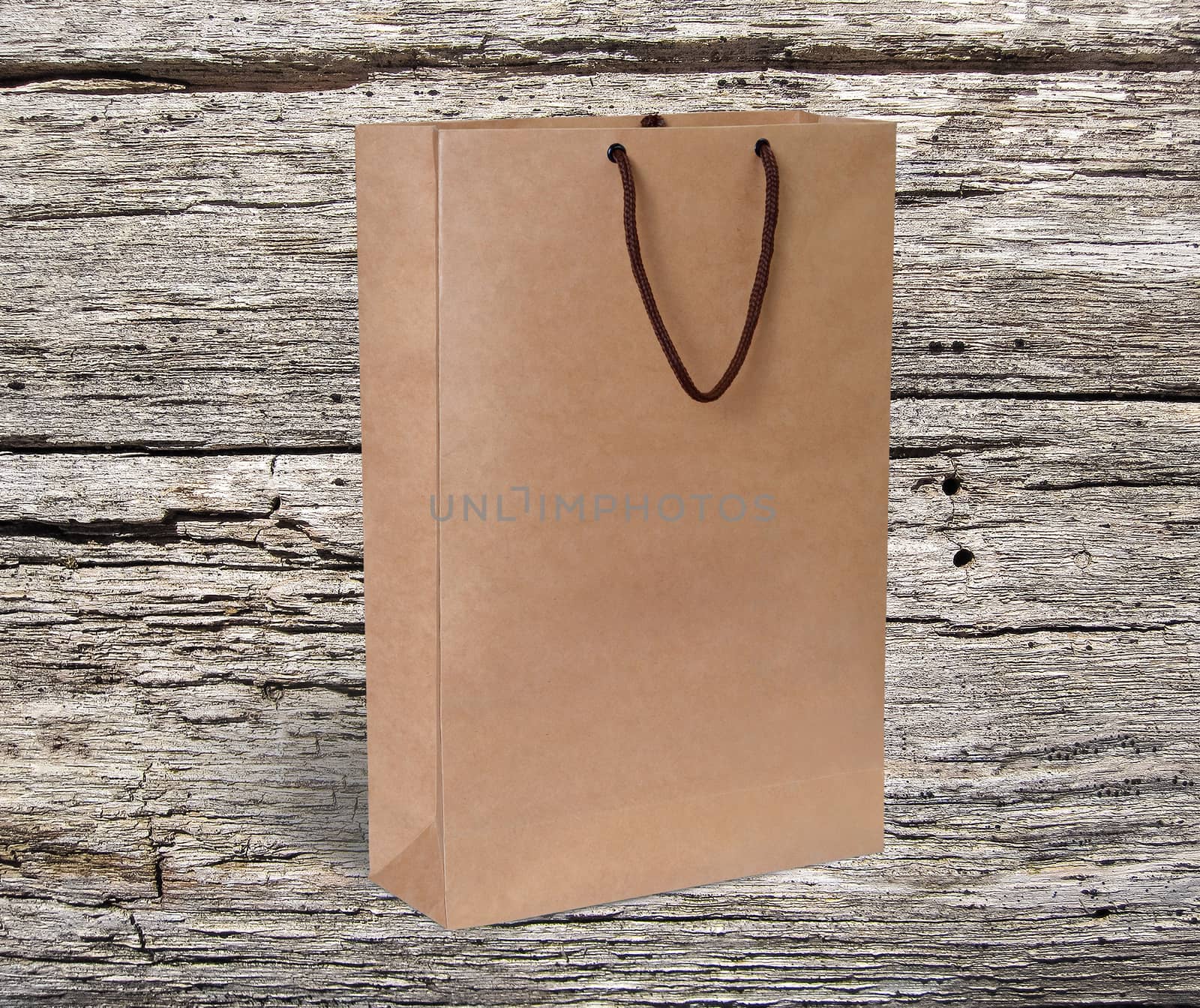 paper bag for shopping on a wooden background by boys1983@mail.ru
