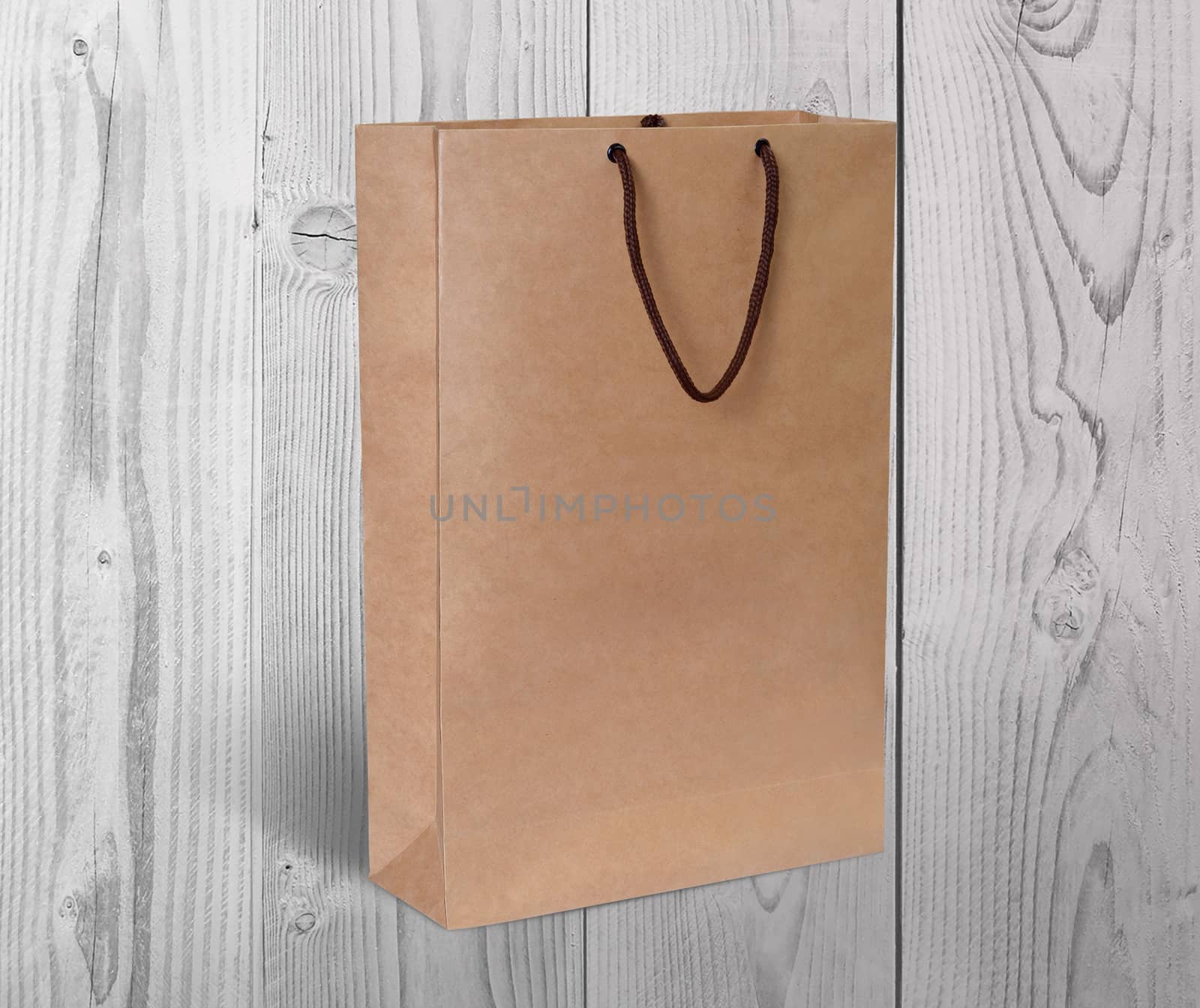 paper bag for shopping on a wooden background by boys1983@mail.ru