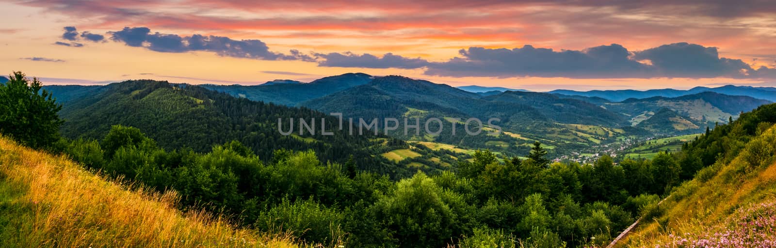 panorama of mountain ridge with peak behind the hillside. beautiful summer background at sunset with red sky