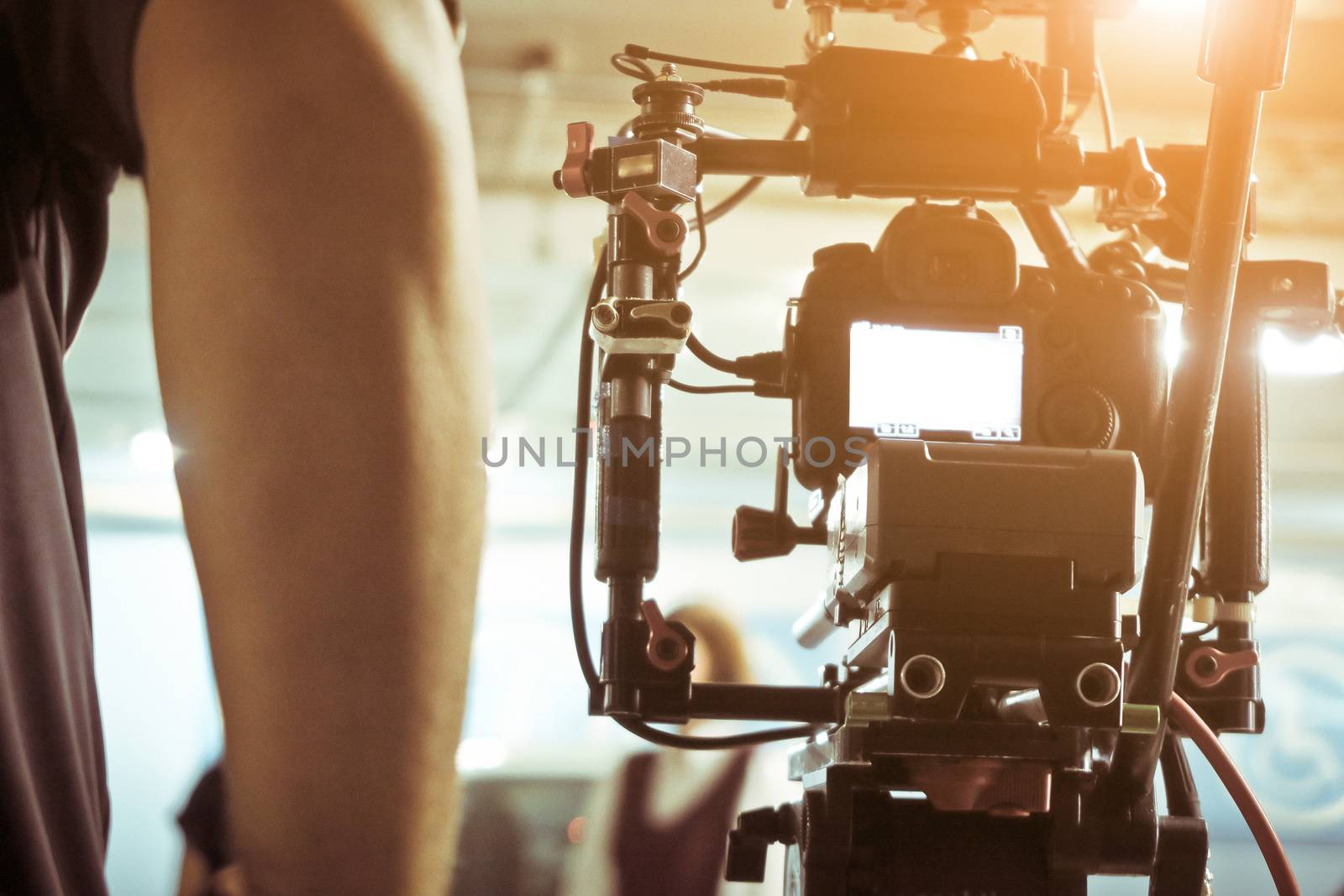 Cameraman with his video camera shooting, Adjusting Camera,film production crew. behind the scenes background.