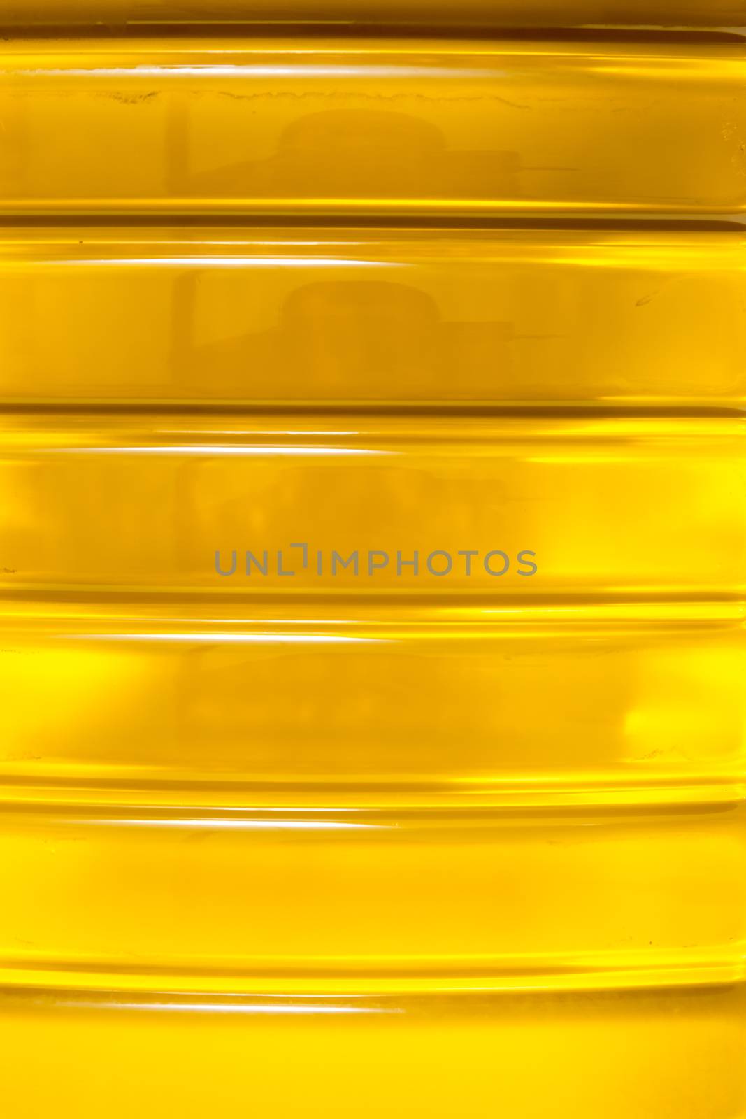 Close up macro of a plastic bottle filled with olive oil.