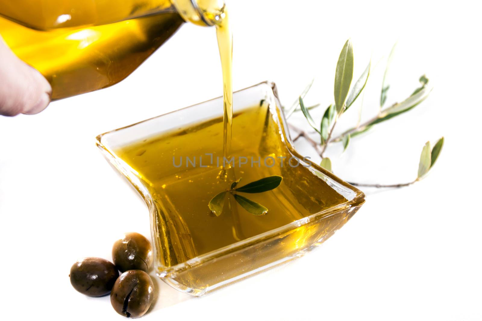 Pouring olive oil in container isolated on a white background.