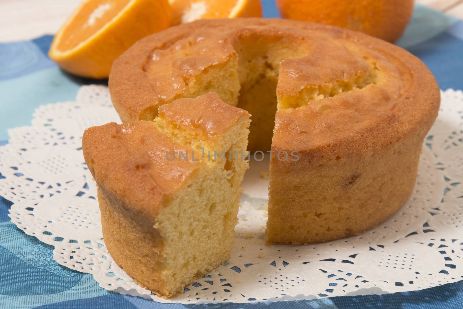 Homemade orange cake on a table with fruit sliced.