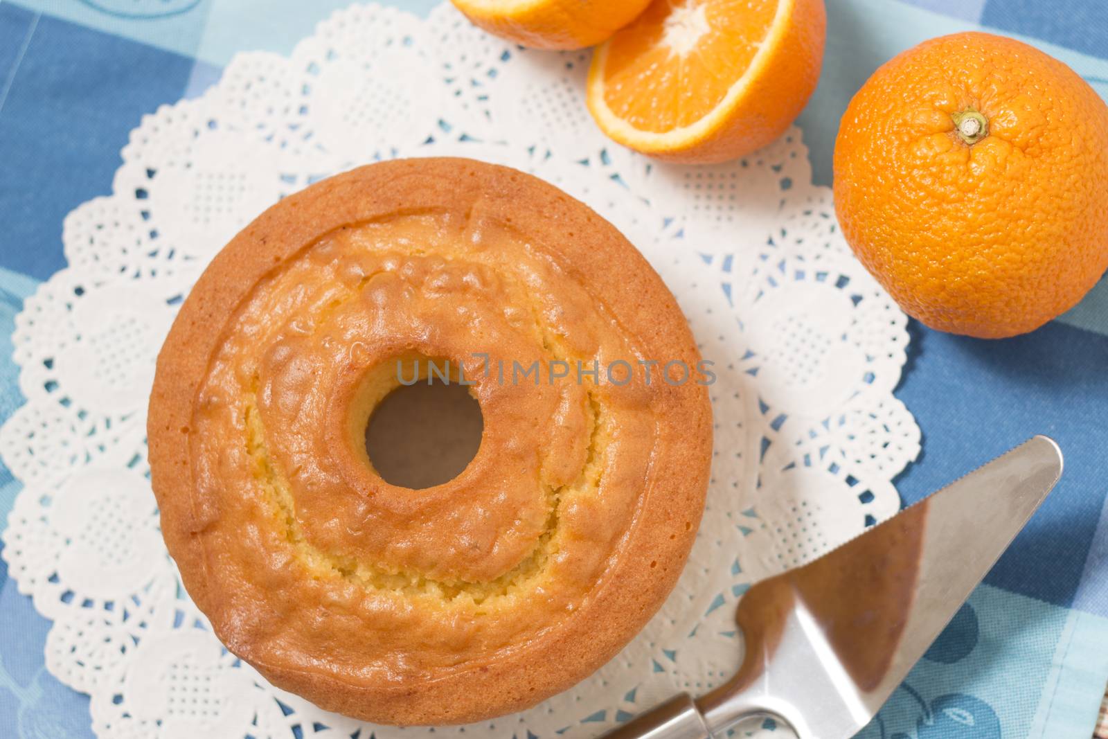 Homemade orange cake on a table with fruit sliced.
