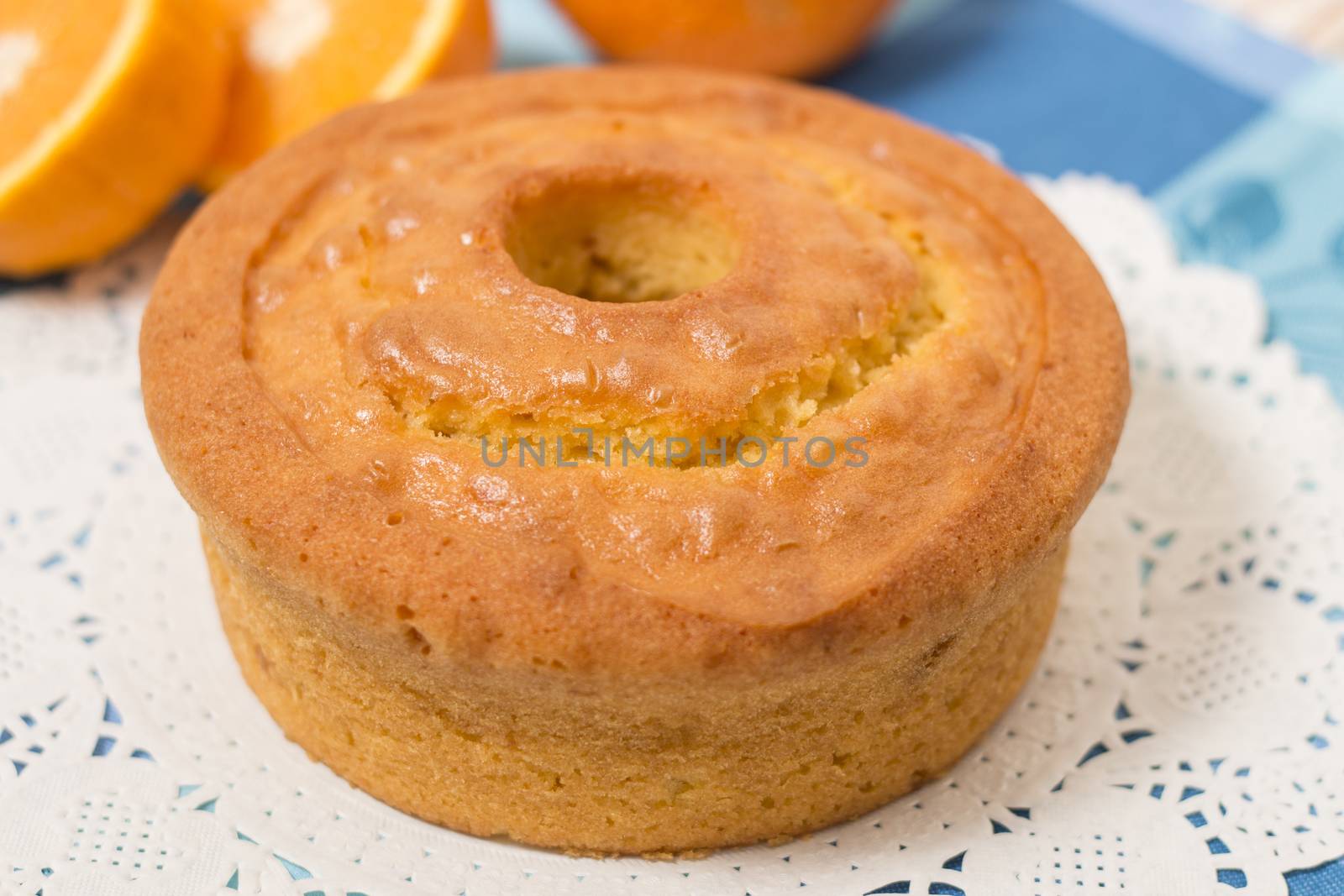 Homemade orange cake on a table with fruit sliced.