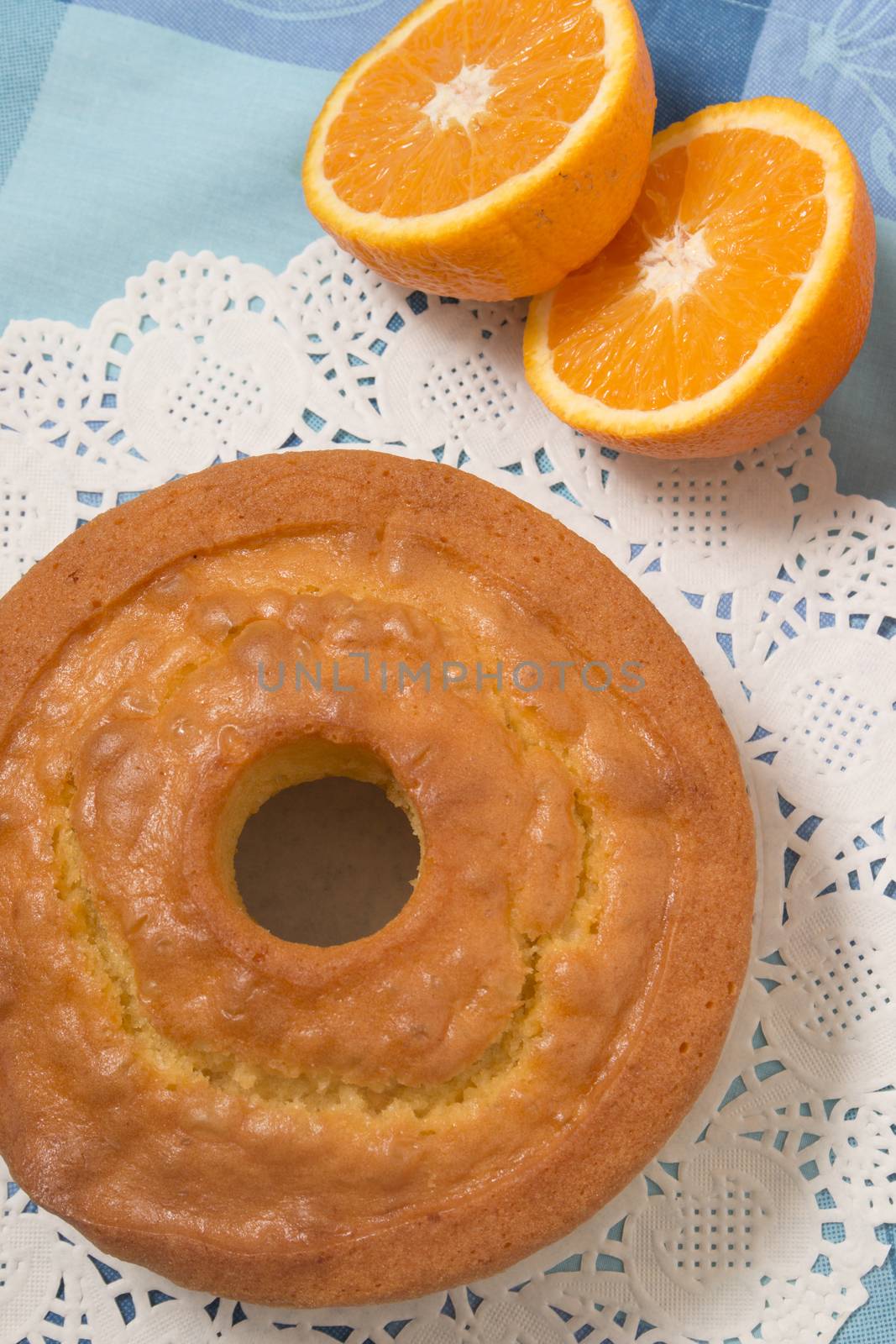 Homemade orange cake on a table with fruit sliced.
