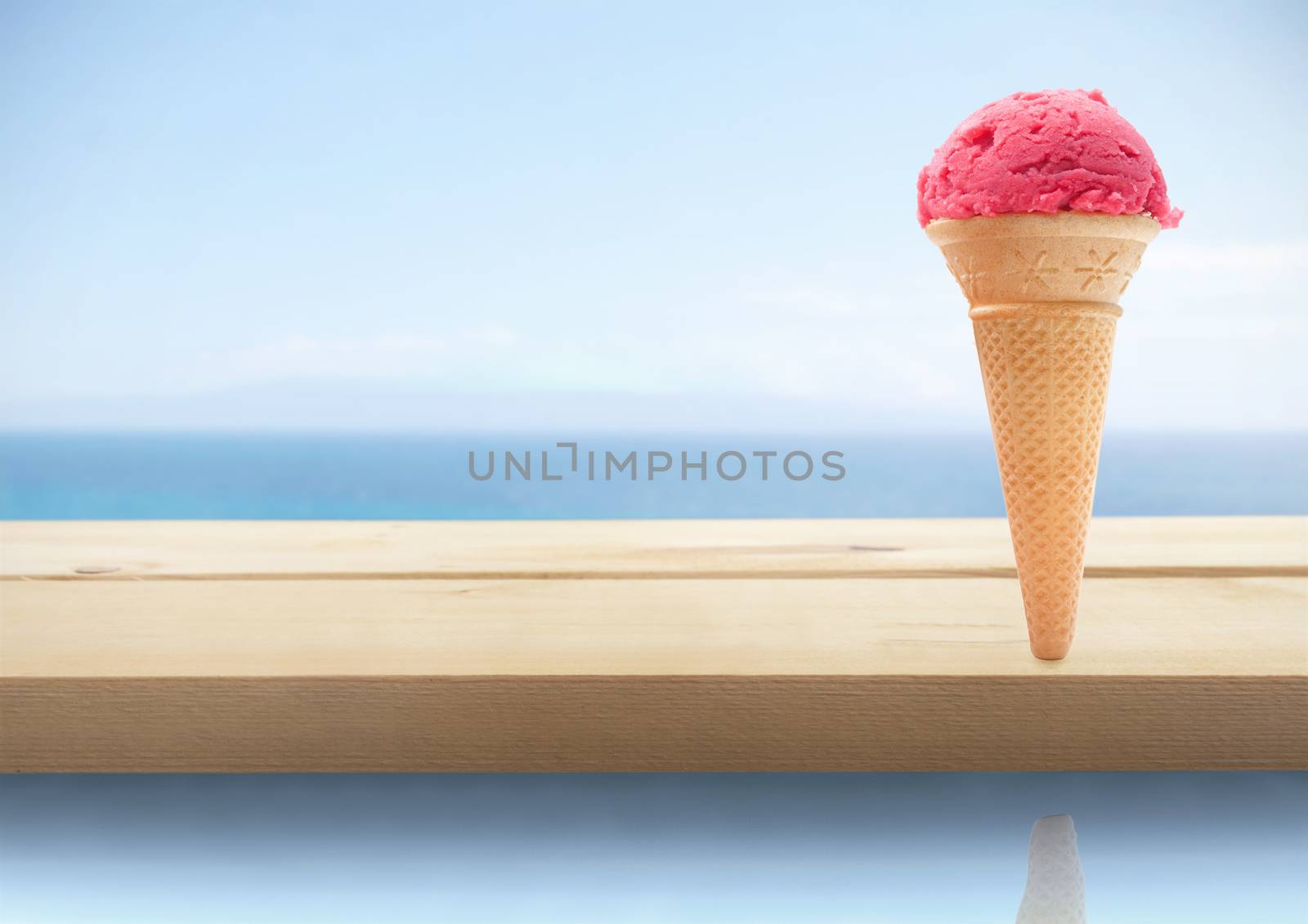 Strawberry icecream cone by a pool side 