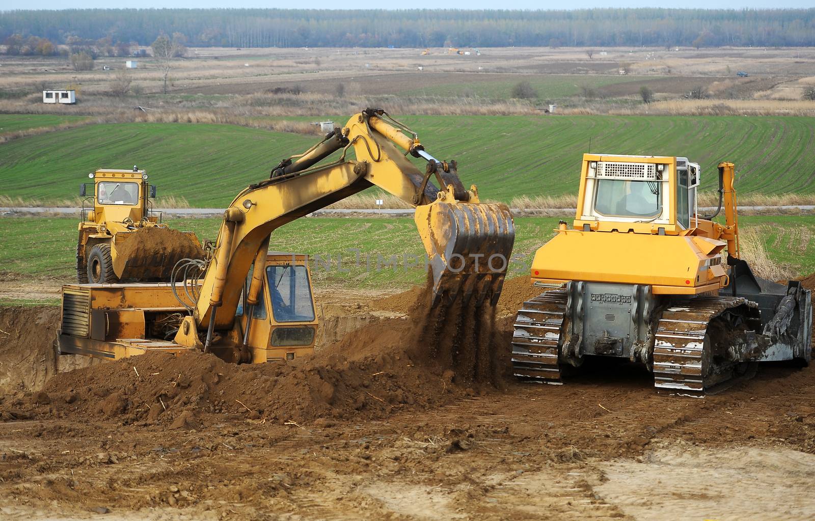 Big bulldozer and excavator in action on construction site