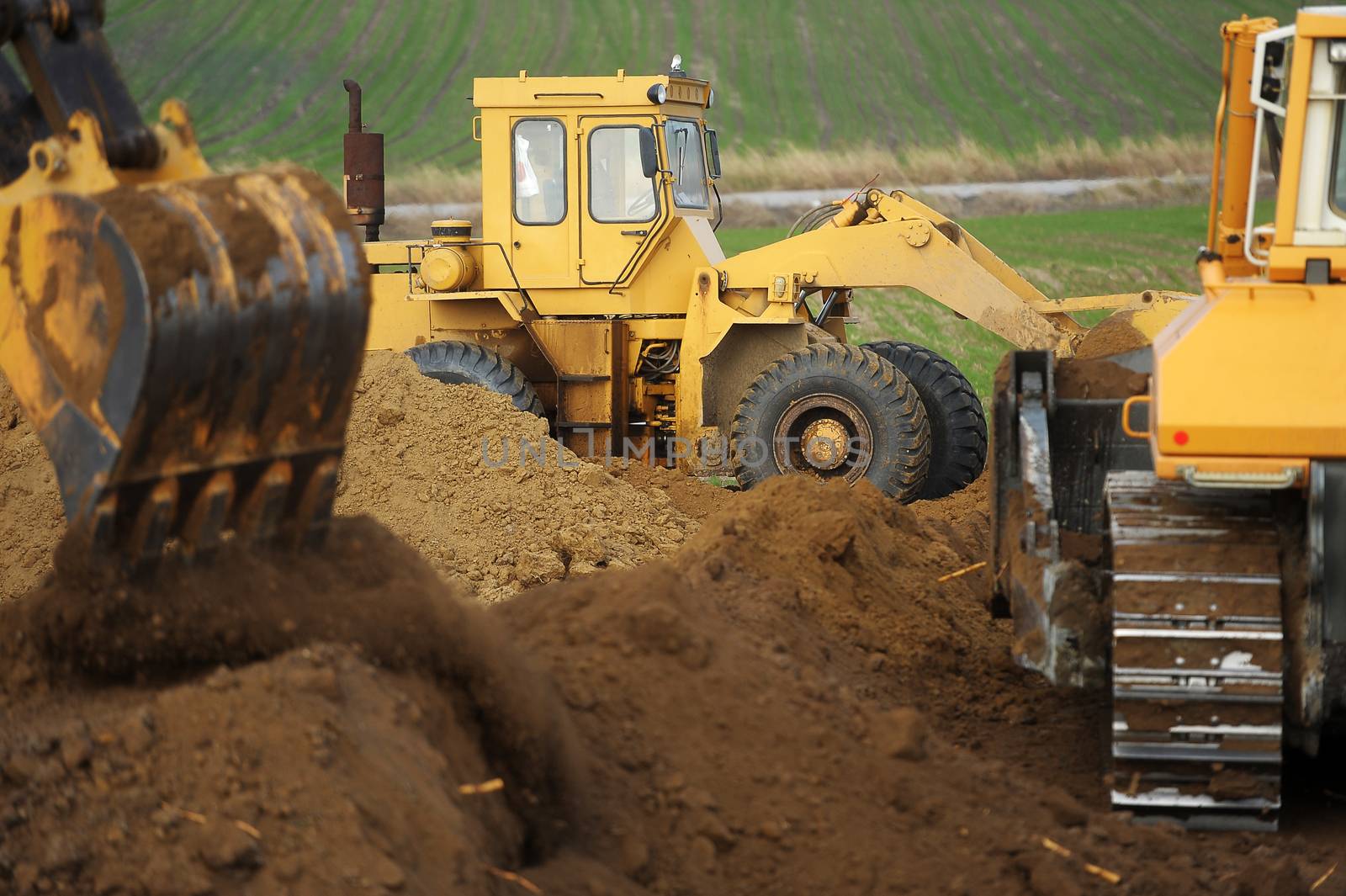 Big bulldozer and excavator in action on construction site