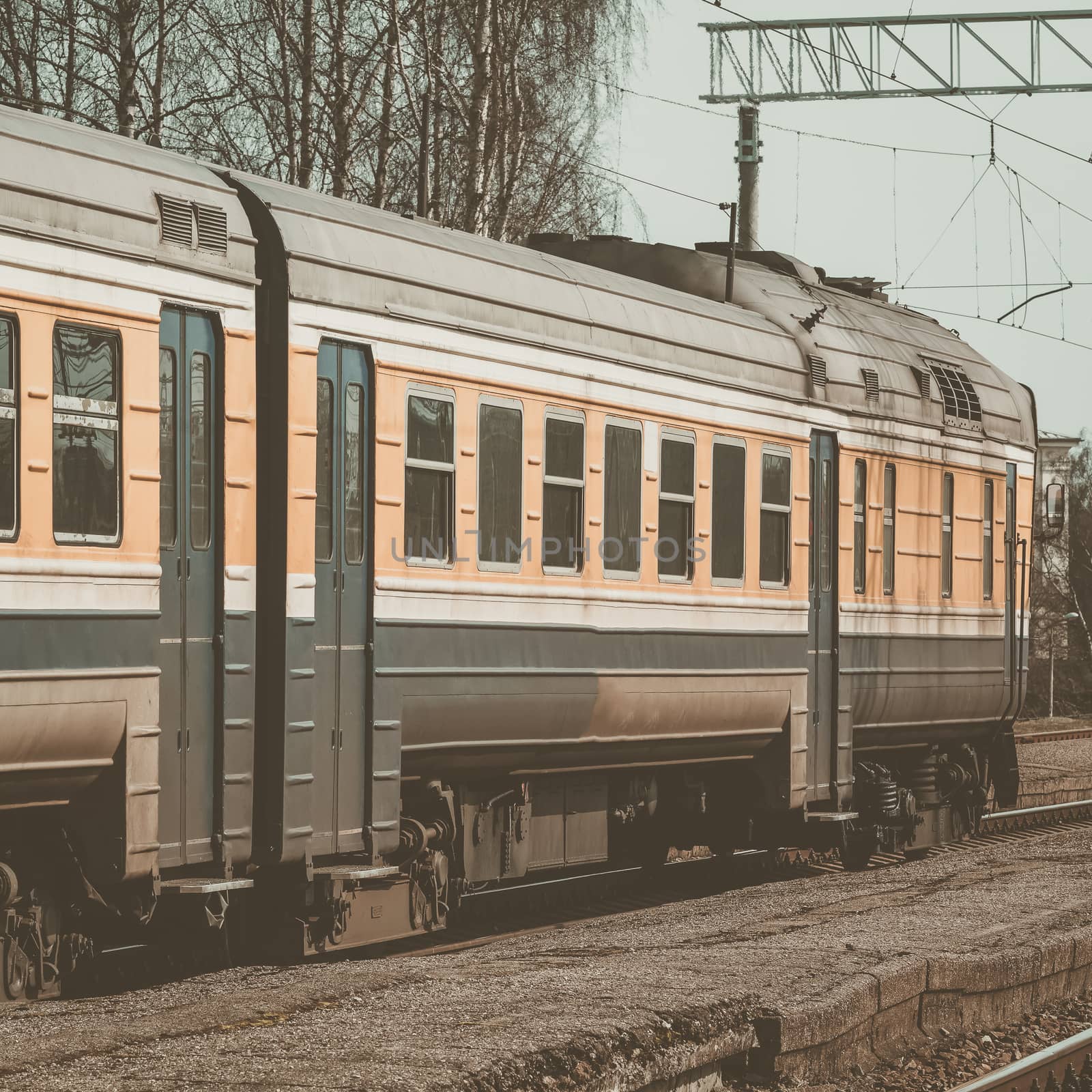 Old yellow passenger diesel train moving at the terminal